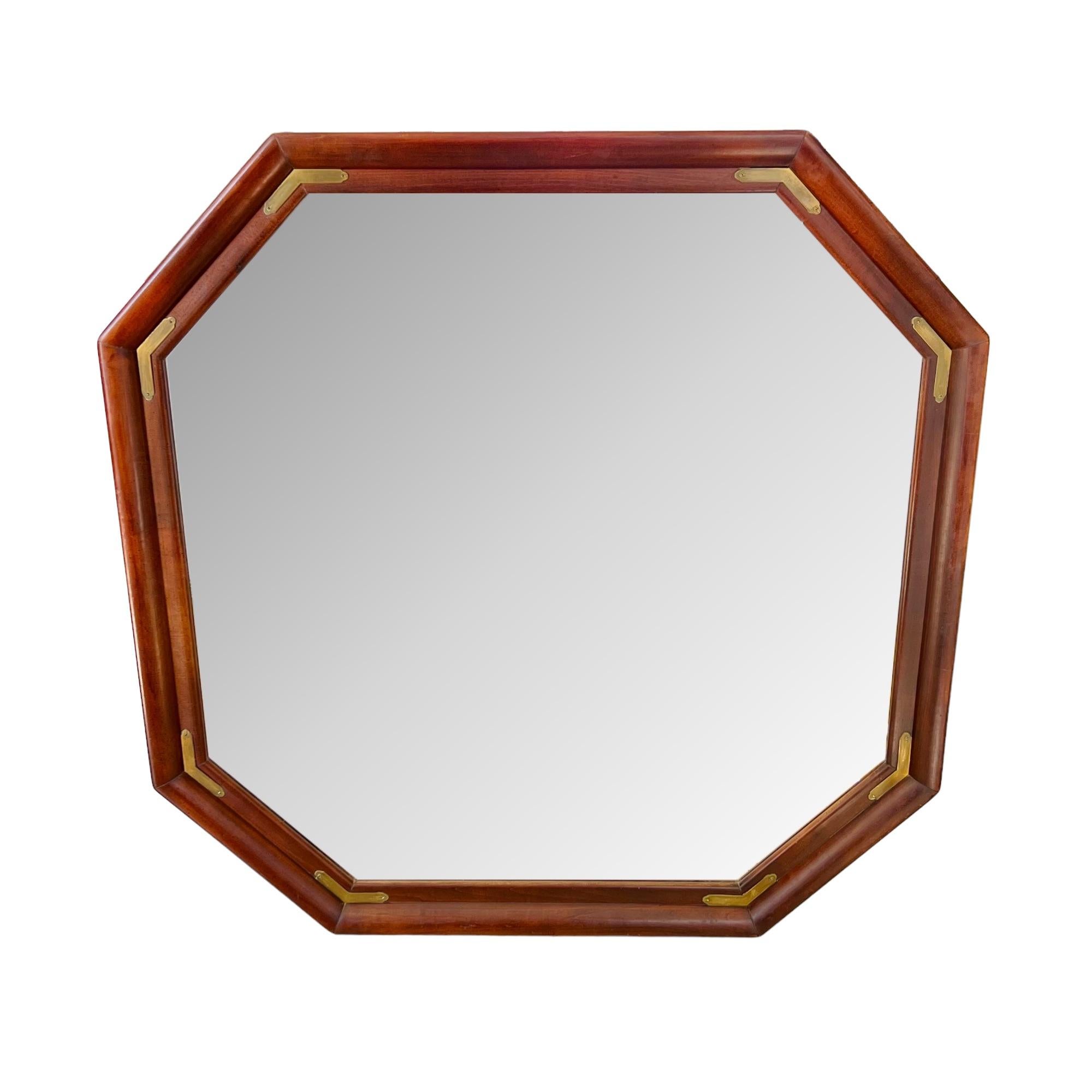 A large vintage campaign style octagonal beveled wall mirror. Wood frame with brass details.

Dimensions: 43