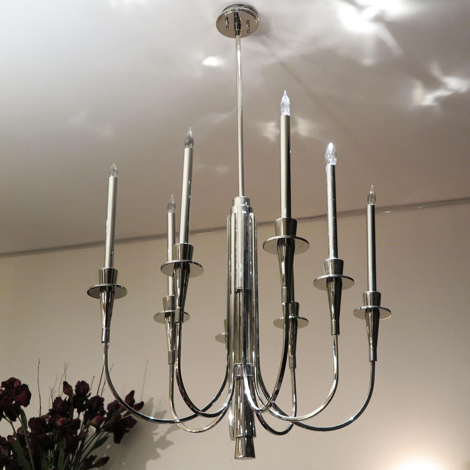 Mid-Century Modern 8-arm chandelier with candelabra style arms and exposed bulbs. Beautifully done in polished nickel. Art Deco inspired design along the stem. The tall candelabra chandelier is ideal for high-ceilings, but can be shortened upon