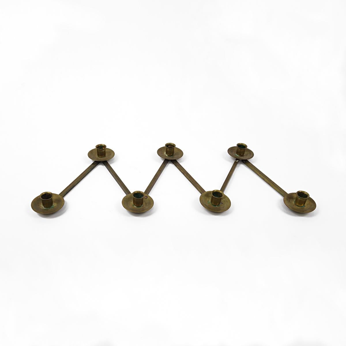 This refined system in a still very up-to-date design dates back from 1950's Sweden: Lars Halmström is the genius behind this brass candlestick that is very flexible in its form as you can see on the pictures. 

As there is a double hinge