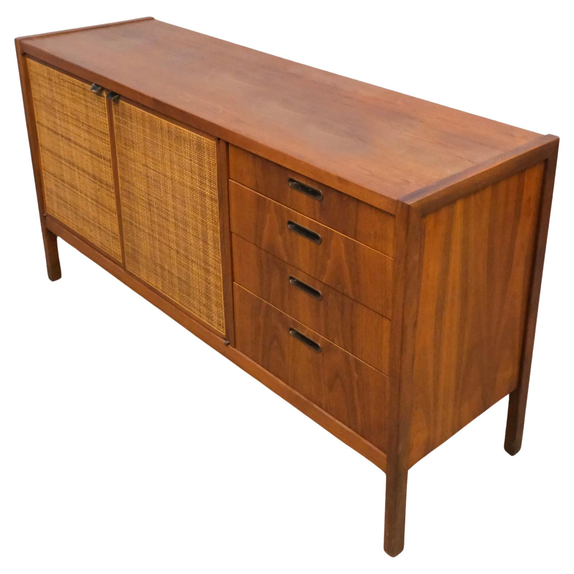 Mid century modern credenza sideboard with two caned cabinet doors and four drawers. The top drawer is fitted for Flatware/silverware. Behind the cabinet doors is an adjustable shelf. Beautiful woodgrain and high quality woodwork. Made in USA circa