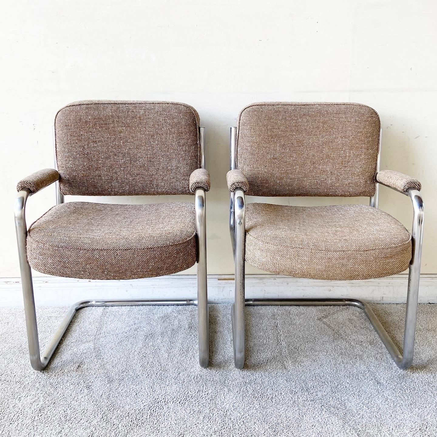 Exceptional pair of Mid-Century Modern cantilever arm chairs. Each feature a brown tweed fabric with a chrome frame.
  