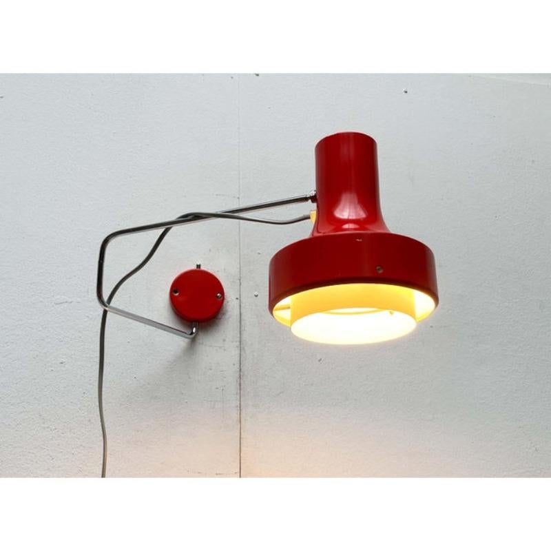Applique murale du milieu du siècle par Napako d'après un dessin de Josef Hurka.

Ce design minimaliste impressionne par ses détails fonctionnels. La tête de la lampe a une forme classique de projecteur. Il est relié à l'arbre par une rotule et peut