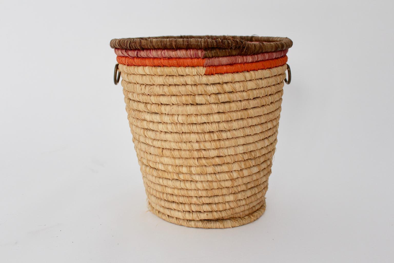 Mid Century Modern vintage basket from raffia in the colors brown, pink, orange.
A very decorative vintage paper basket from straw with two brass handles, Vienna, circa 1950.
Throughout its stunning shape with two brass handles and the beautiful