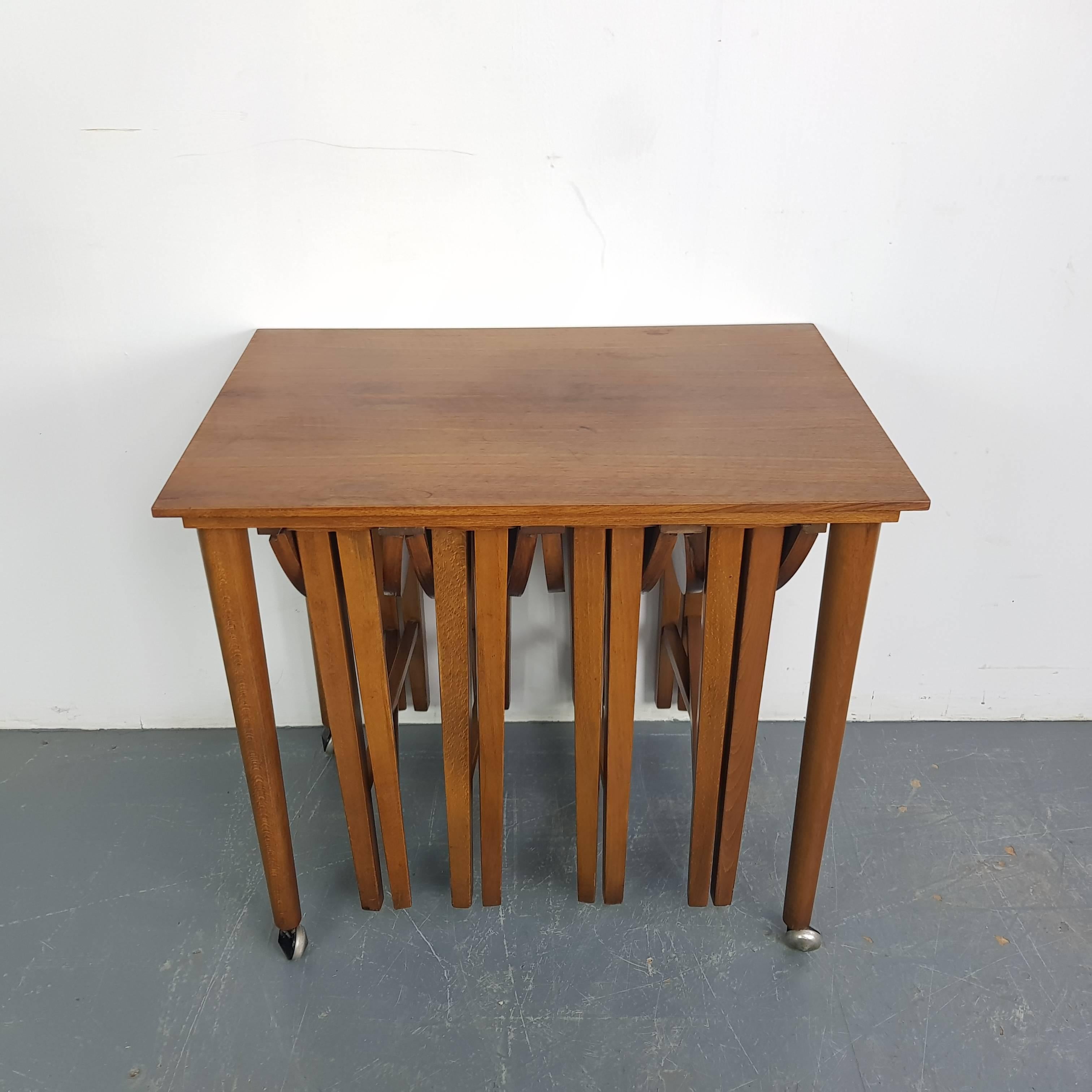 Mid-Century Modern Carlo Jensen style nesting table set.

This unique vintage set of nesting tables in the style of Carlo Jensen comes with four collapsible serving tables that slide neatly under their rectangular counterpart.

In good vintage