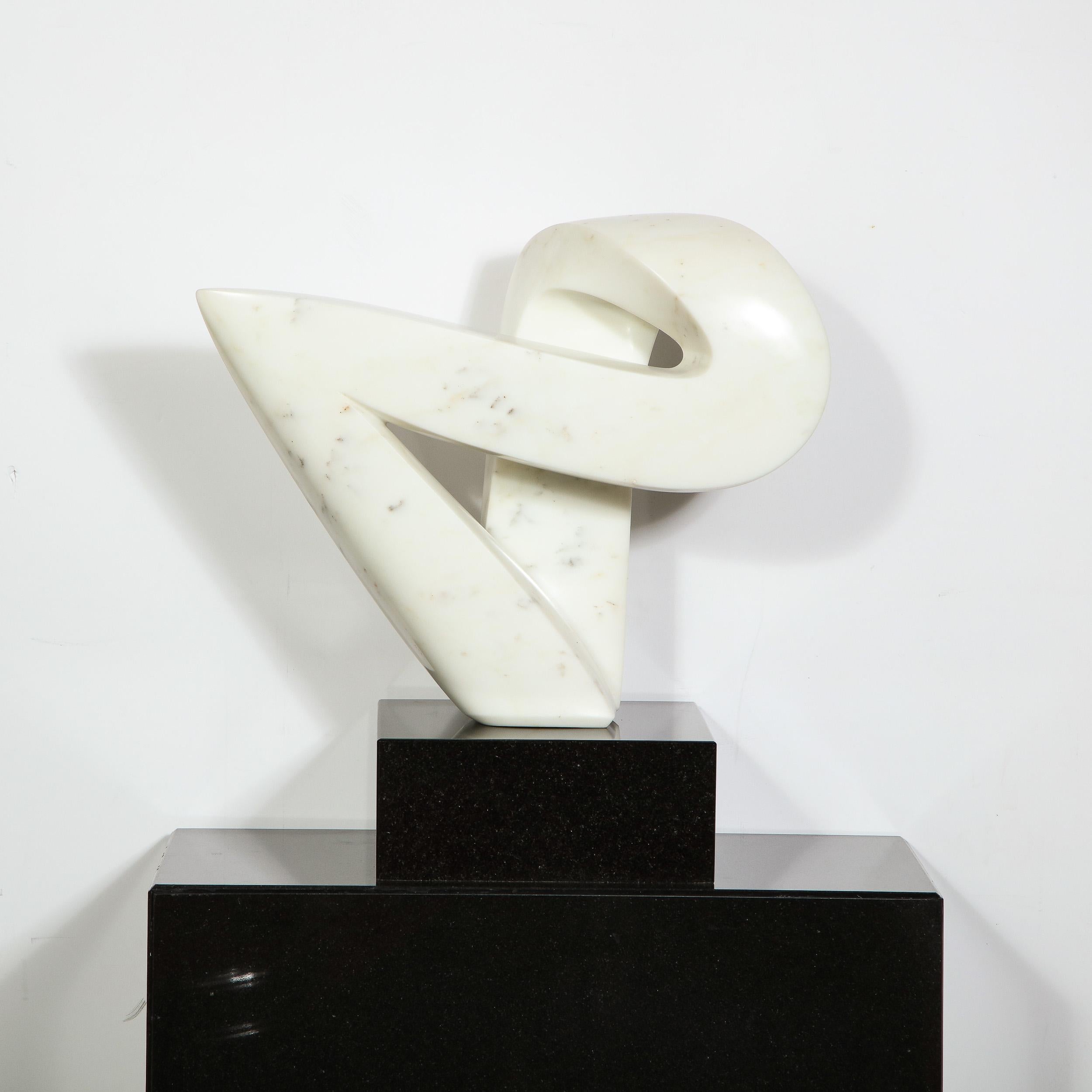 This elegant Mid-Century Modern sculpture was realized in the United States, circa 1970. It features an organic abstract sinuously curved form- full of verve and dynamism- with a flawless rounded surface in white Carrara marble. It sits on a large
