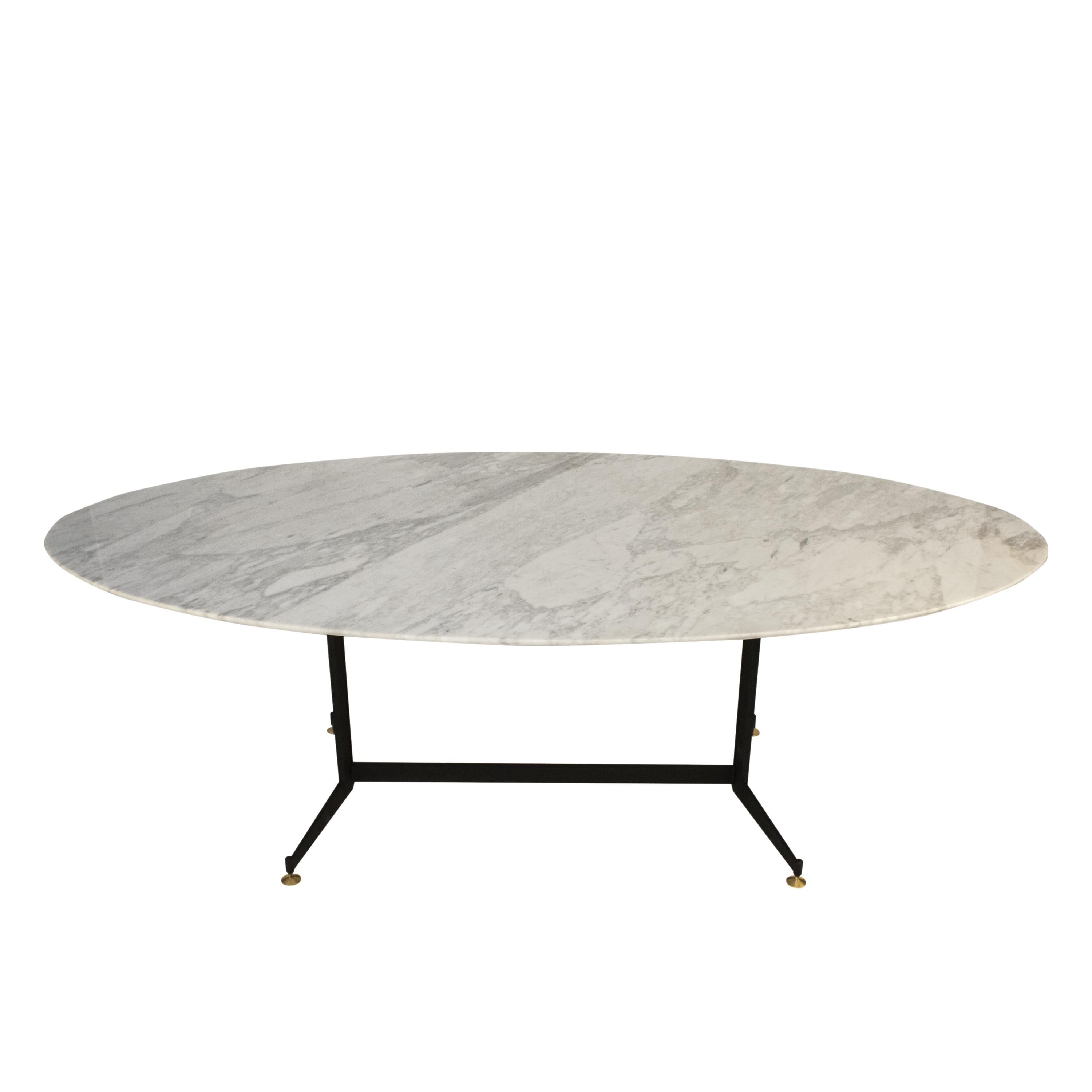Italian mid-century modern oval dining table from the 1950's. 

The table is made up of a metallic foot with four legs lacquered in black and leveling pads finished in aged brass. The 2 cm thick oval Carrara marble top with a flute peak edge finish