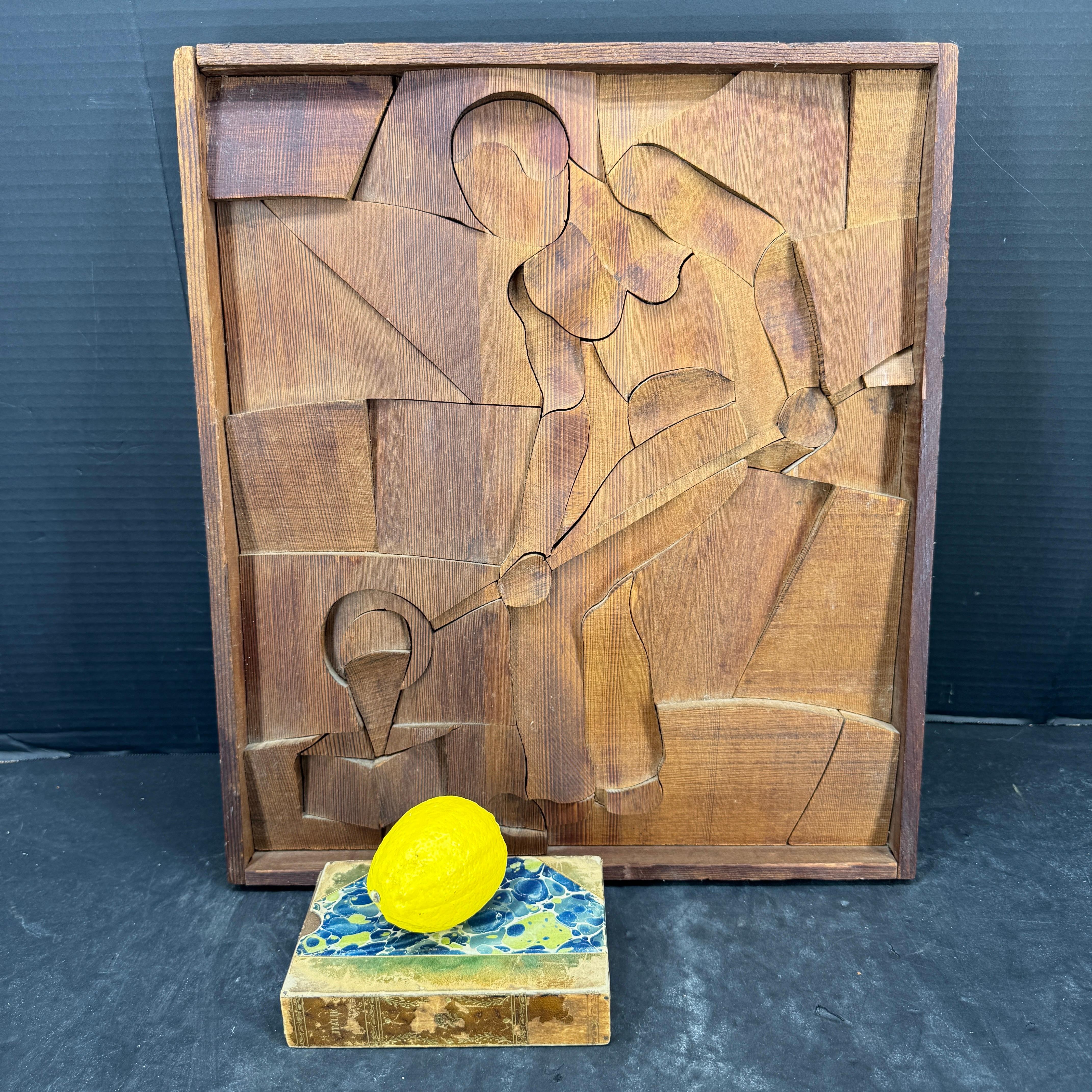 One of a kind art featuring a carved wooden art piece featuring multiple curved pieces that have been put together as a puzzle giving this art a multi-dimensional piece. When we saw this framed art, we felt this evokes a drawn in artistic