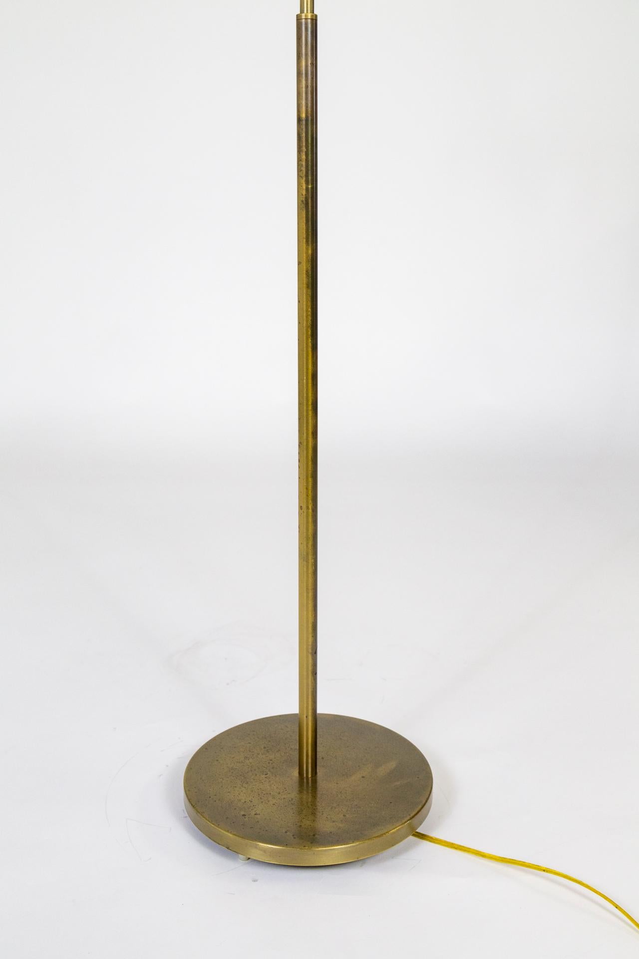 A modern, adjustable pharmacy lamp by Casella. Made of brass with rich, aged patina; round base and a sleek, dome-clamshell shape shade. New dimmer socket and heavy base. Measures: Adjustable height 44-49” x 10