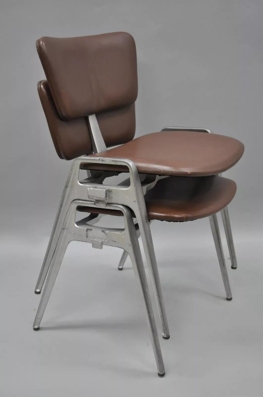 Paire de chaises d'appoint empilables en fonte d'aluminium vintage par Crucible Products Corp. Cet article se caractérise par une construction en aluminium moulé empilable, des côtés imbriqués avec des crochets, un revêtement en vinyle marron, une