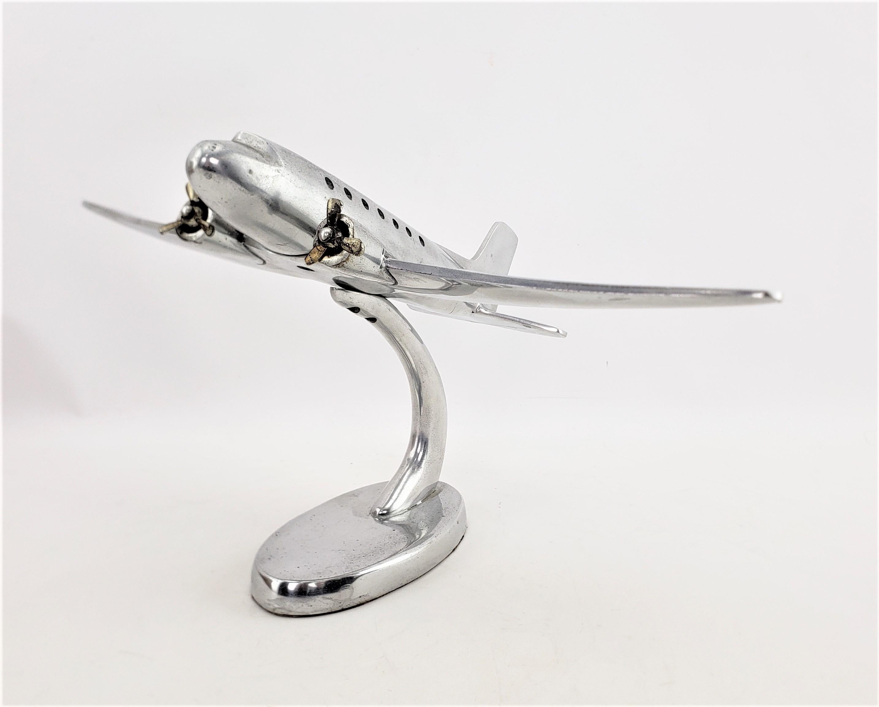 This airplane model or sculpture is unsigned, but presumed to have originated from the United States and dating to approximately 1945 and done in the period streamlined Mid-Century Modern style. The plane is composed of cast and brushed aluminum