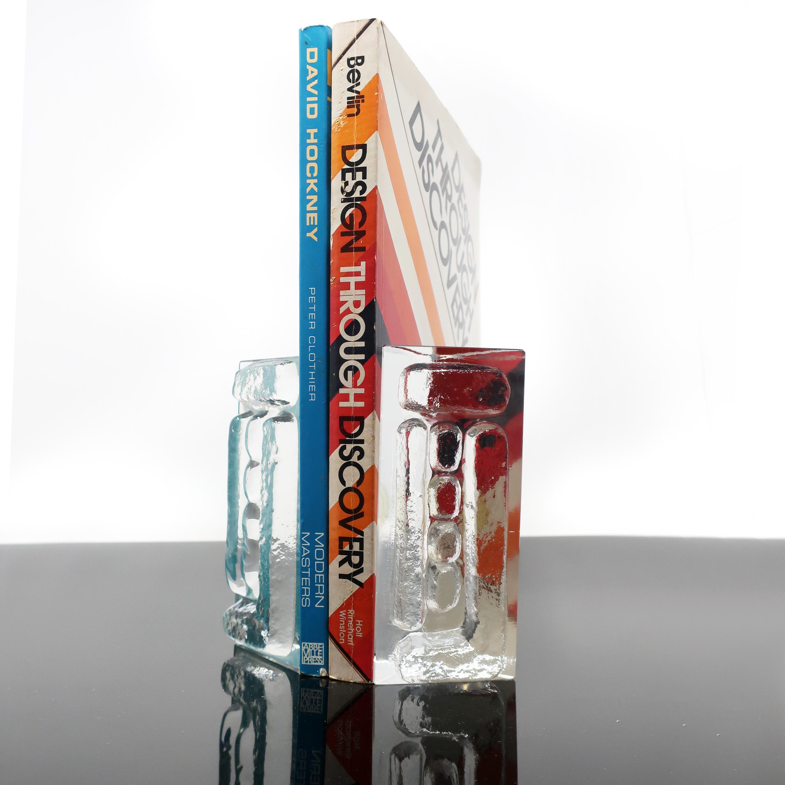 A pair of triangular Mid-Century Modern cast glass bookends by Colony with a Brutalist design on one side. In the style of Blenko. 
 
In excellent condition with original sticker.

2