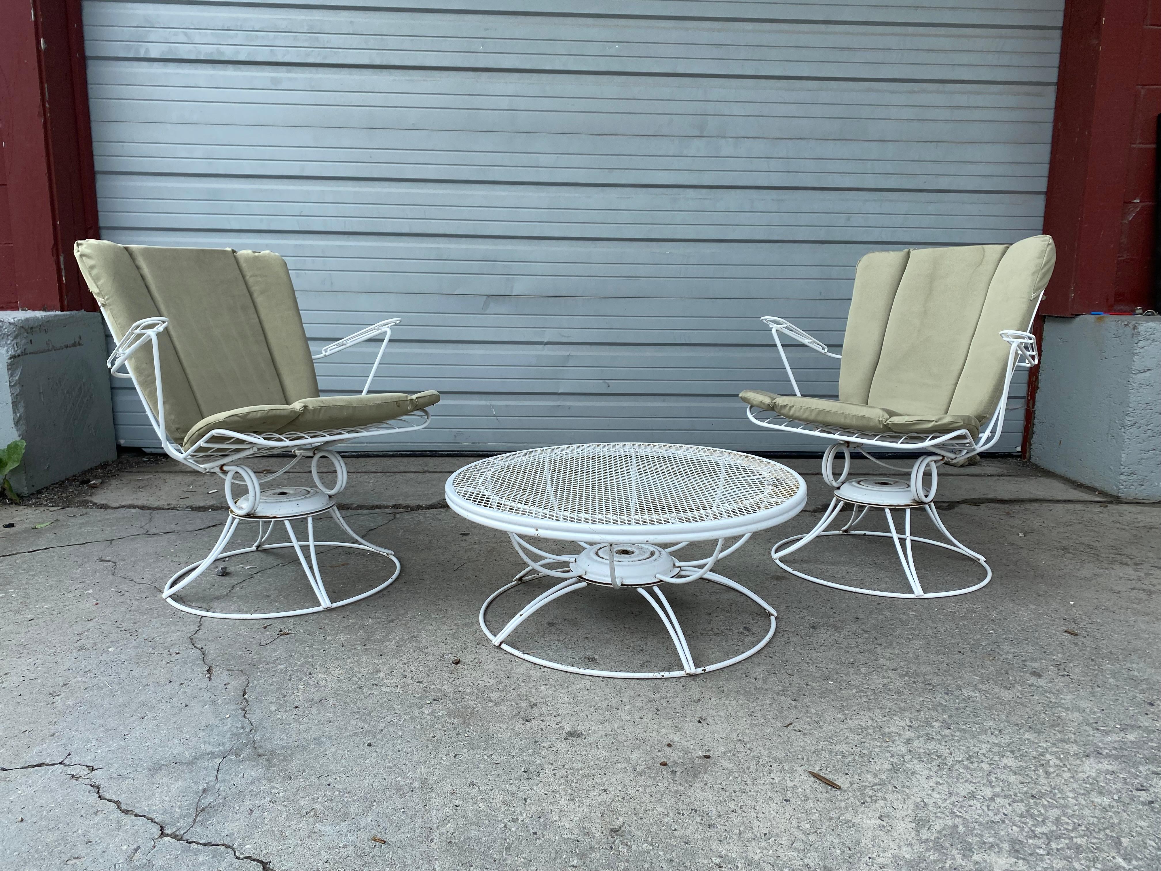Offered is a pair of vintage Mid-Century Modern iron swivel/rocker patio lounge chairs (model 36) and seldom seen lazy Suzan coffee or cocktail table made by Homecrest by Bottemiller, circa 1968. These chairs swivel and rock, and retain original