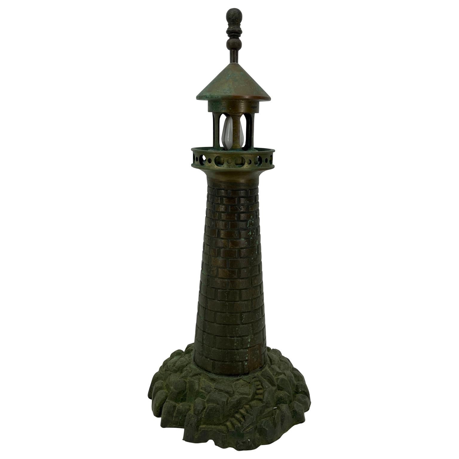 Mid-Century Modern cast iron lighthouse table lamp. This lamp is a beautiful rendering of a classic lighthouse. It's green patina is soothing; beautifully carved and quite sturdy, this lighthouse will glow in any decor.