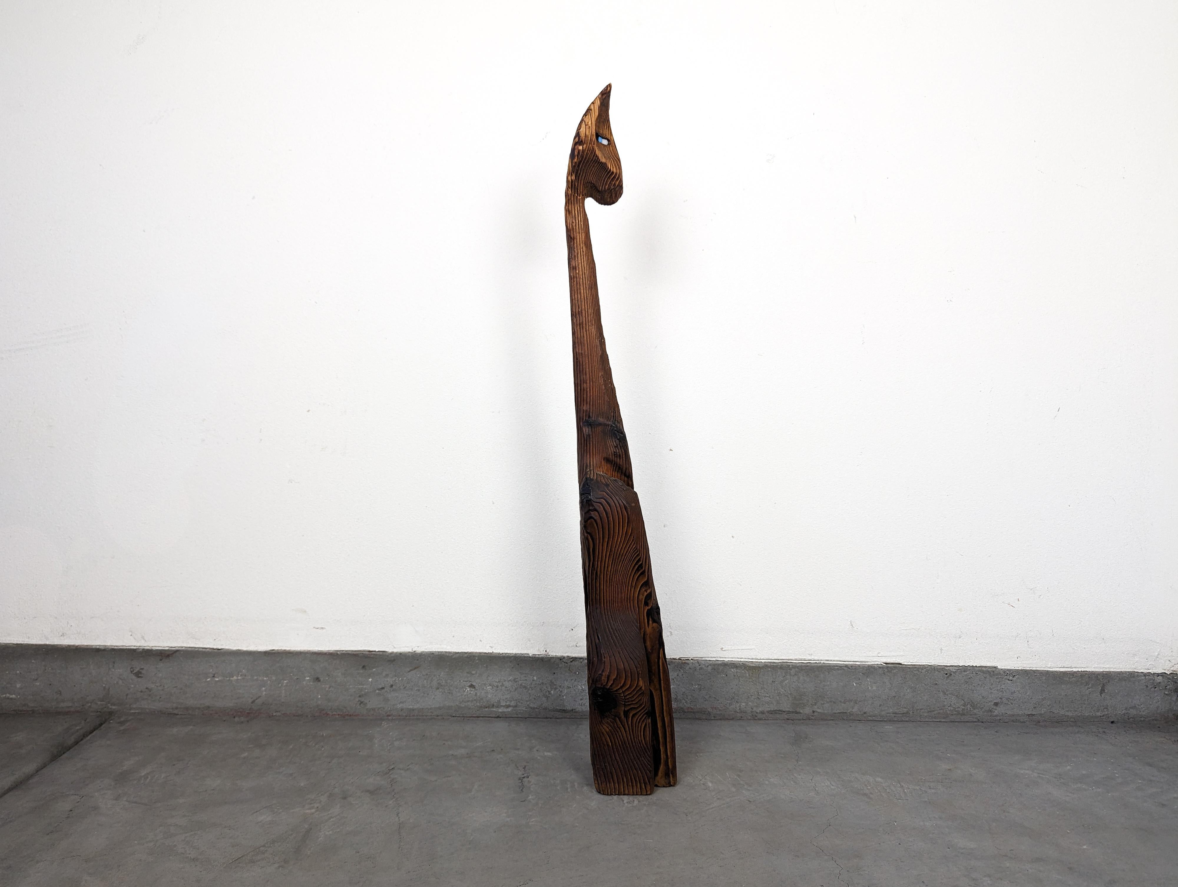 Crafted from cedar wood, known for its beautiful grain and enduring quality, this sculpture stands an impressive 41.375 inches high and 5 inches in width and depth. Its vertical format makes it an ideal piece to feature in various spaces within your