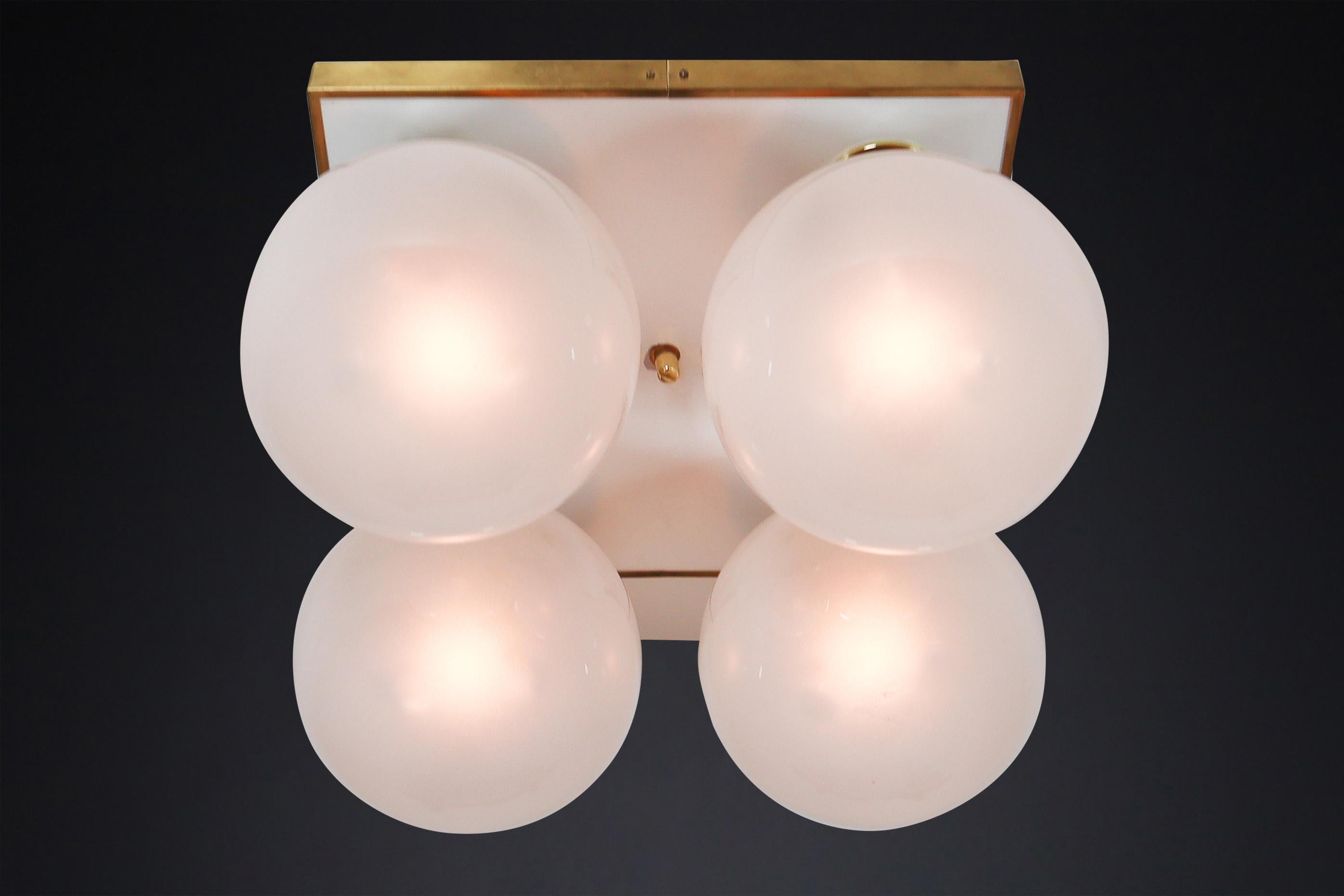 Mid-Century Modern Brass Ceiling Chandeliers with Four Pearl White Glass Globes.

This set of large midcentury brass ceiling lights or flush mounts was designed by Preciosa and produced in the Czech Republic during the early 1970s. With their brass
