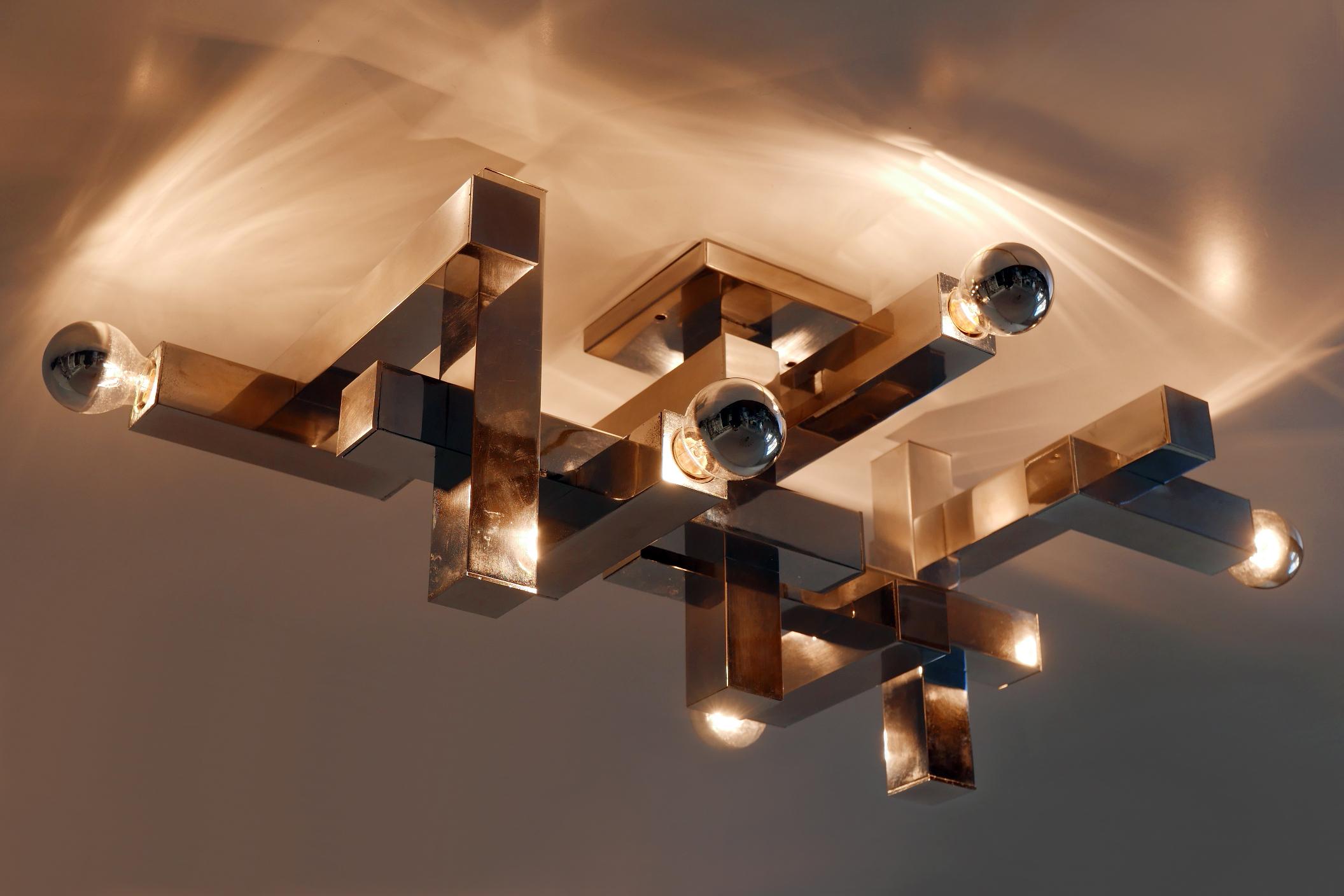 Rare, architectural Mid-Century Modern ceiling fixture or wall lamp with overlapping rectangular tubes. Designed and manufactured by Gaetano Sciolari, 1970s, Italy.

Executed in chrome-plated steel, the lamp comes with 6 x E14 / E12 Edison screw