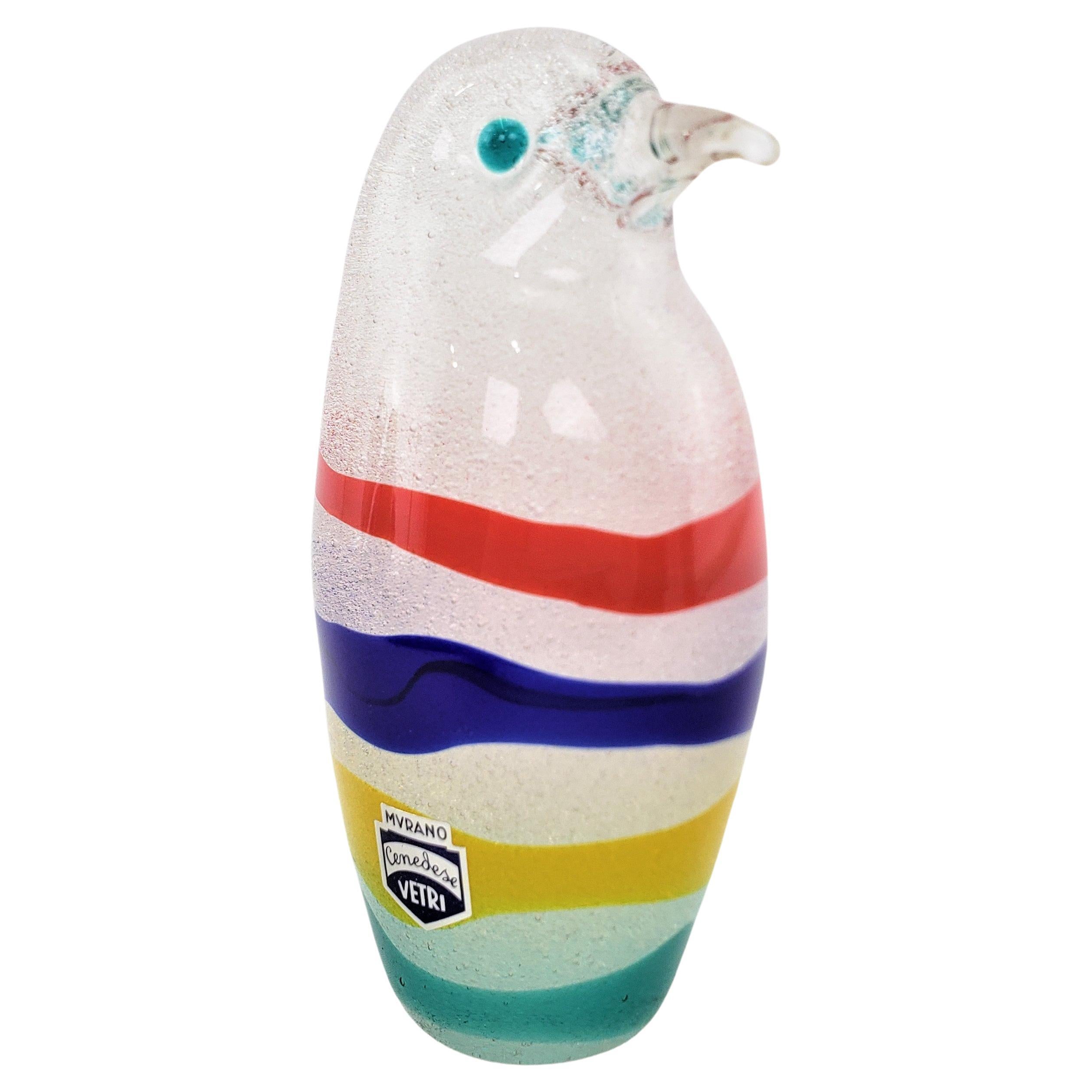 This art glass penguin figurine was made by the renowned Cenedese art glass factory of Murano Italy in approximately 1965 in a period Mid-Century modern style. The sculpture is done with thick hand formed glass with multi-colored bands around the