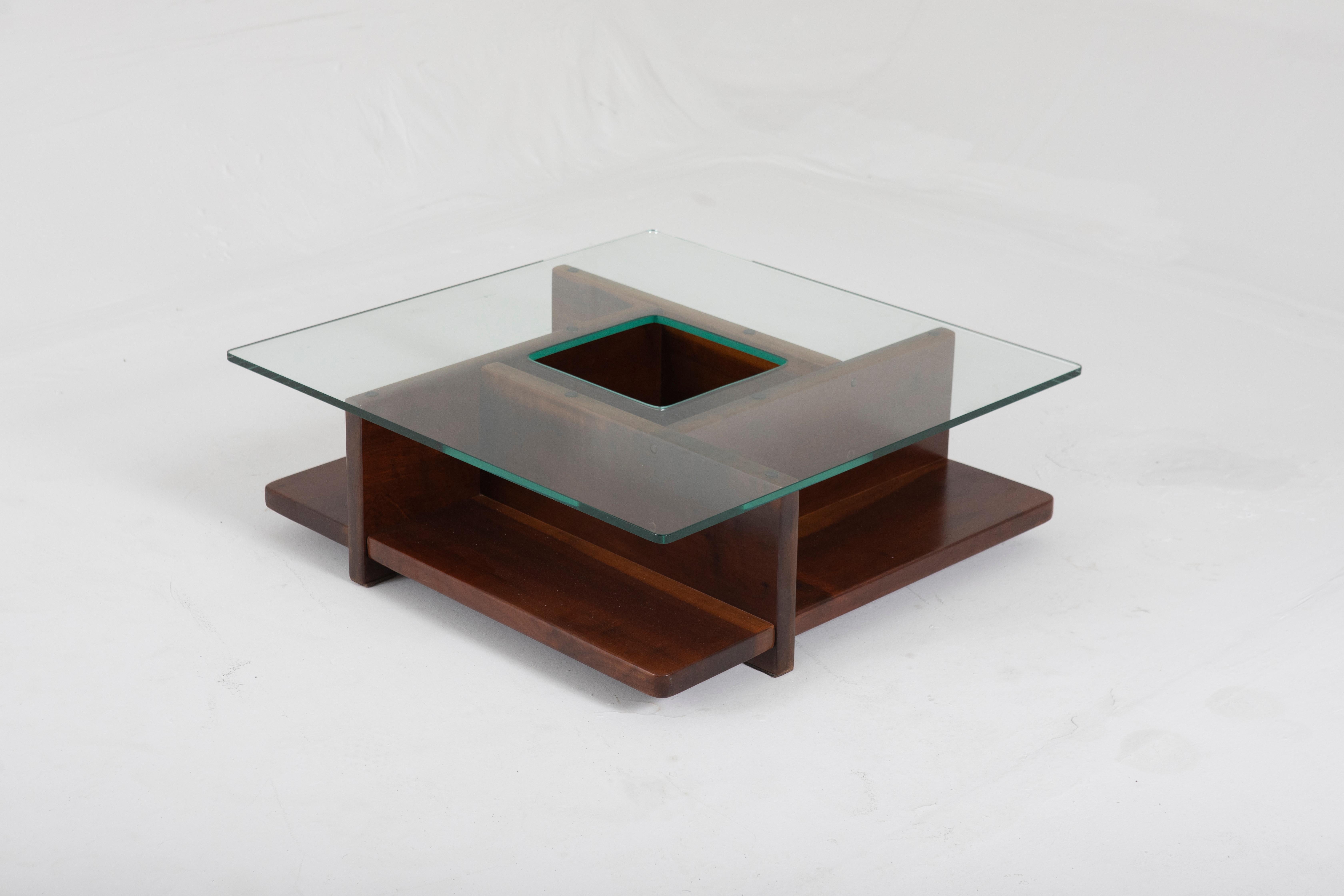Mid-Century Modern Center table by Casa Finland, 1960s

Square coffee table made of wood with a glass top. It has a hole in the middle of the glass, which forms a compartment in the center of the table.