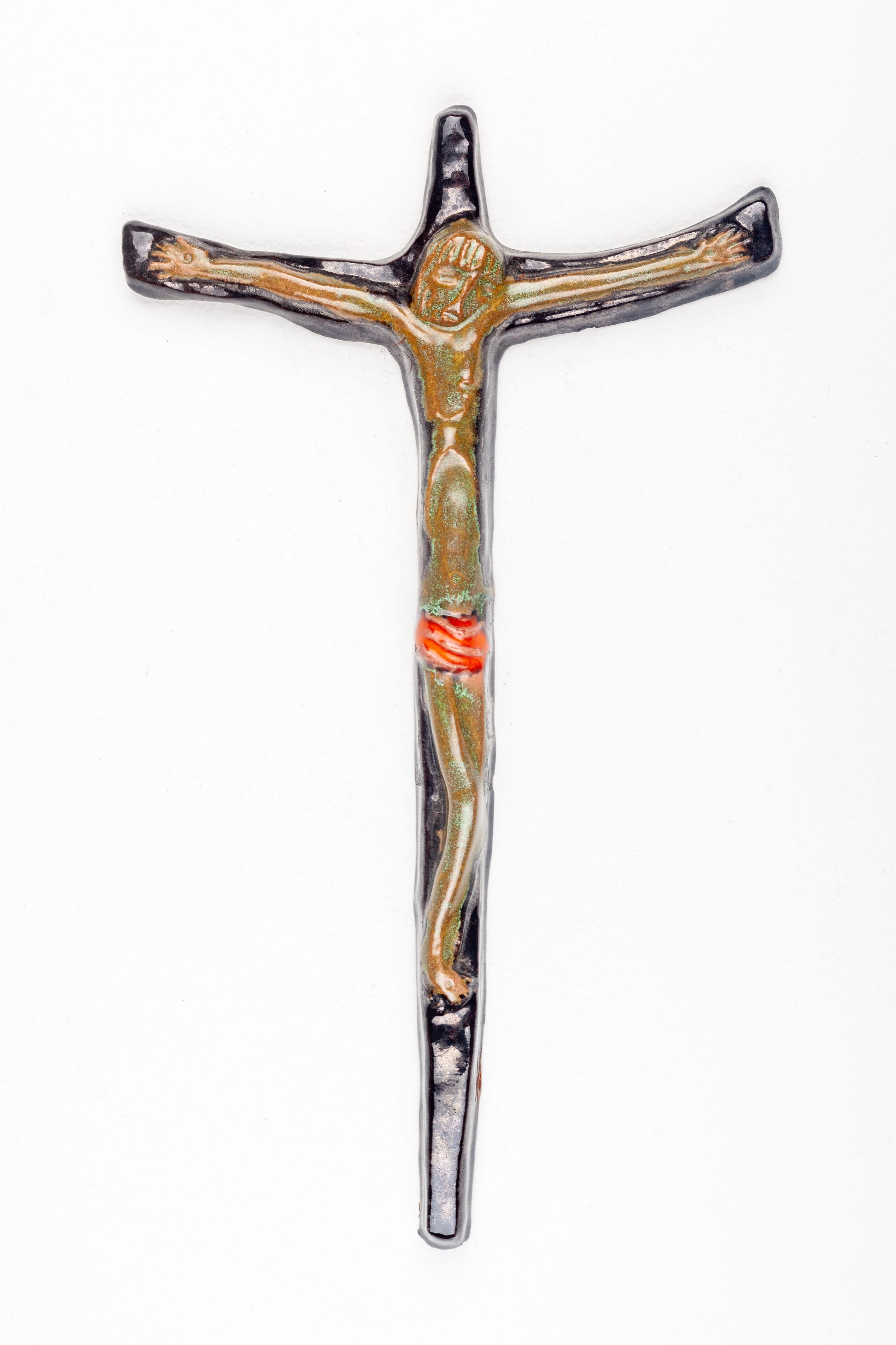 This ceramic crucifix is a fine example of mid-century modern religious art, handcrafted by an unknown European studio pottery artist. The piece is marked by a minimalist silhouette that adheres to the mid-century modern aesthetic, with a subtle