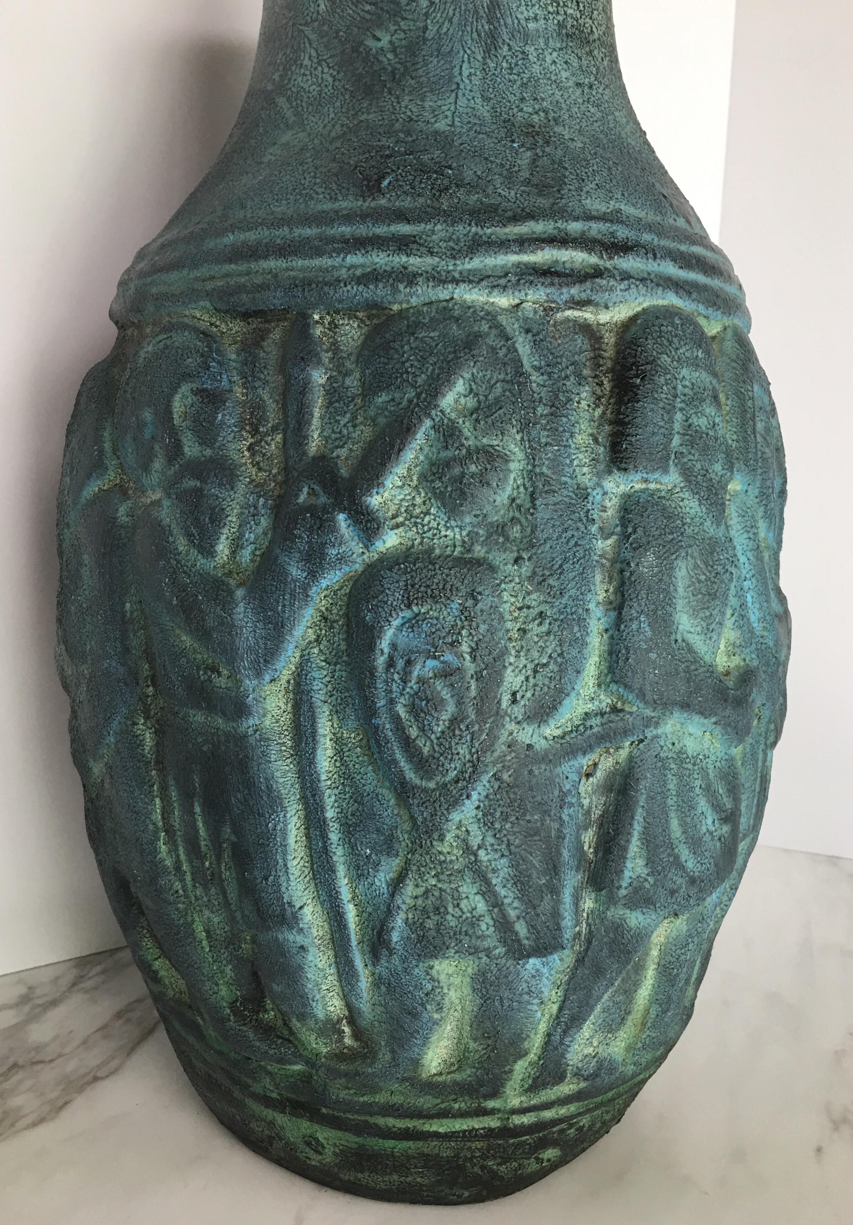 Large Mid-Century Modern ceramic pottery vessel featuring dimensional figures in a matte turquoise textural finish. 
This sculptural handmade vase is marked 