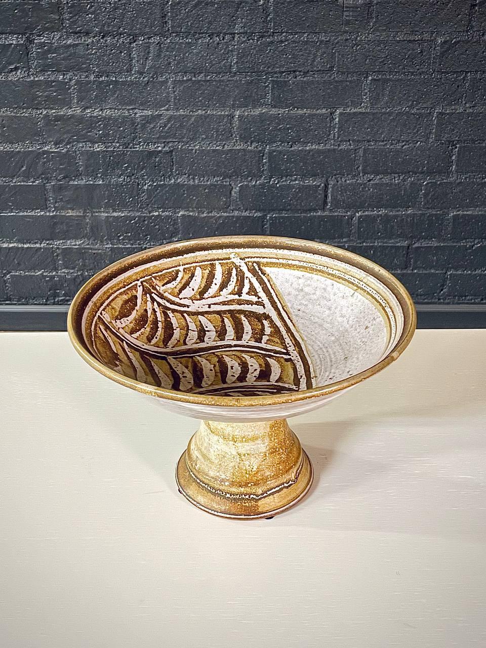Condizioni: Condizioni originali d'epoca

Designer: Firmato
Produttore: Firmato
Materiali: Ceramica smaltata

Questa ciotola d'epoca ha una forma rotonda e poco profonda e poggia su un piedistallo. L'interno della ciotola è decorato con un motivo di