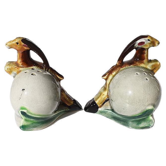 A pair of vintage Mid-Century Modern gazelle or antelope motif ceramic salt and pepper shakers. This pair is created from ceramic and glazed in beautiful brown, black and pale green paint. The craquelure throughout adds a very vintage feel. They are