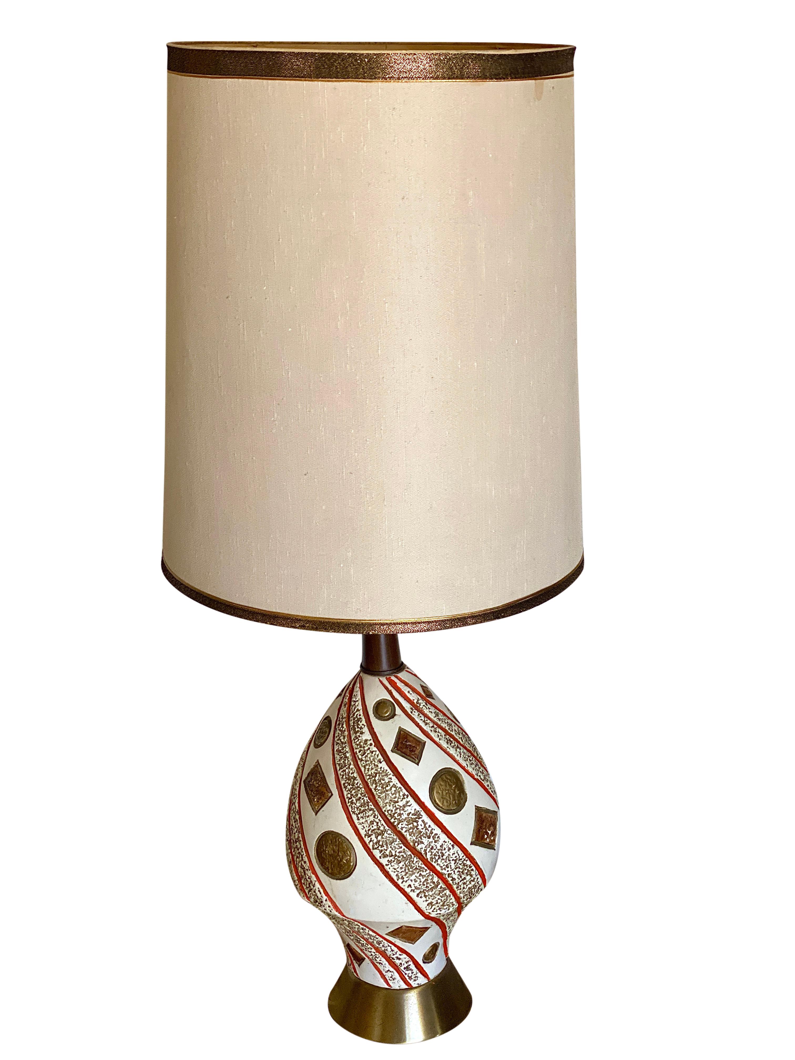Abstract orange and cream ceramic Mid-Century Modern lamp with brass base and teak neck. The gold in the pottery is luminescent. Makes a bold statement with subtle colors that blend with any interior. The lampshade is no longer available because of