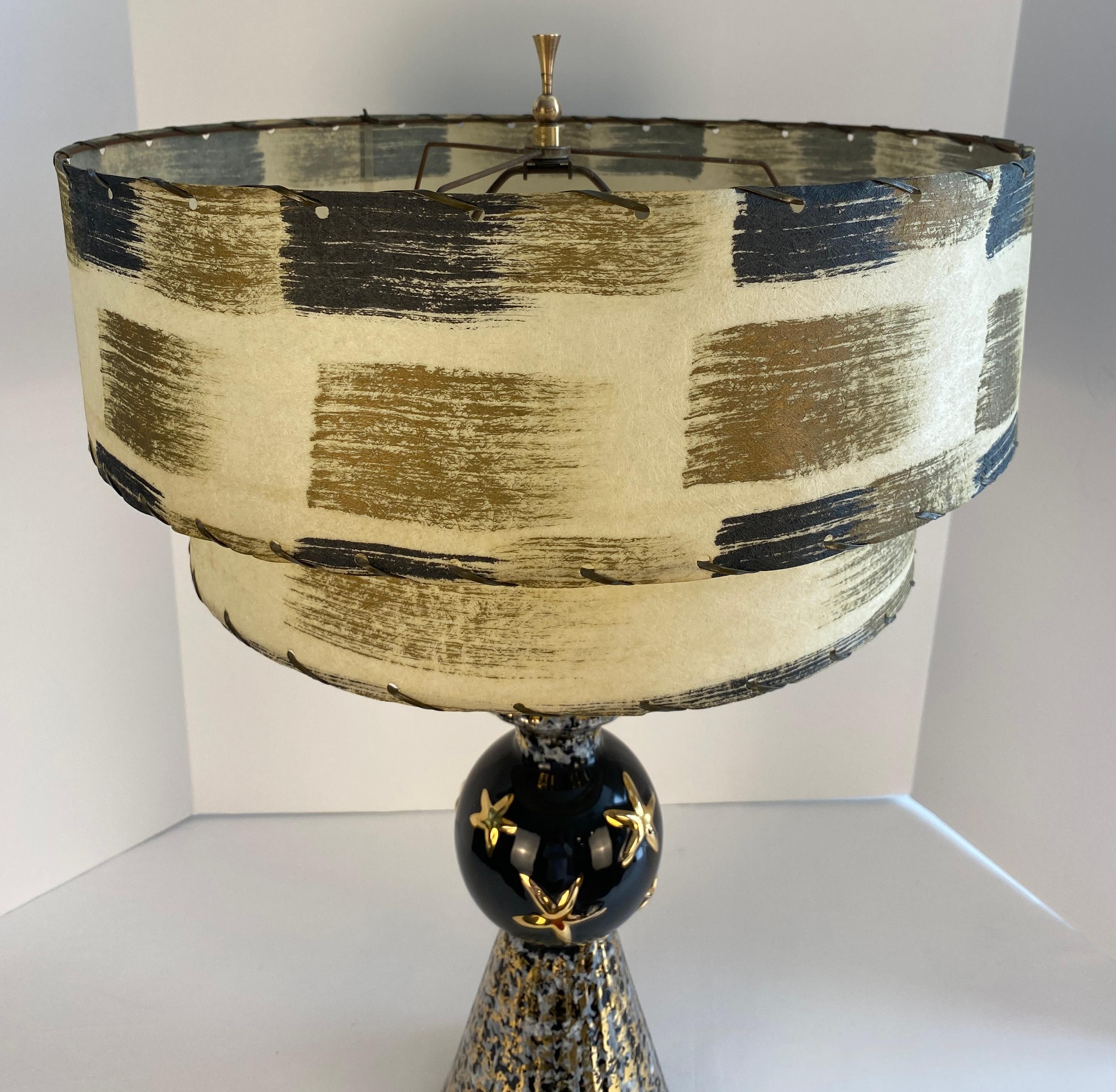 Illuminate your space with a Mid-Century Modern Style Table Lamp
a hint of Hollywood Regency style. This unusual MCM black and gold table lamp 
Measures: 26