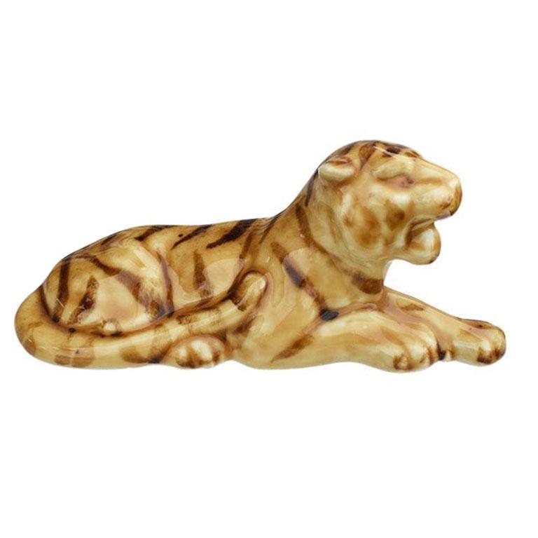 A ceramic lioness figurine glazed in brown and cream. This mid-century statue will be a fabulous addition to a bookshelf or side table. Created from ceramic, it depicts a lioness reclining on her front paws, with her mouth wide open mid-roar. The