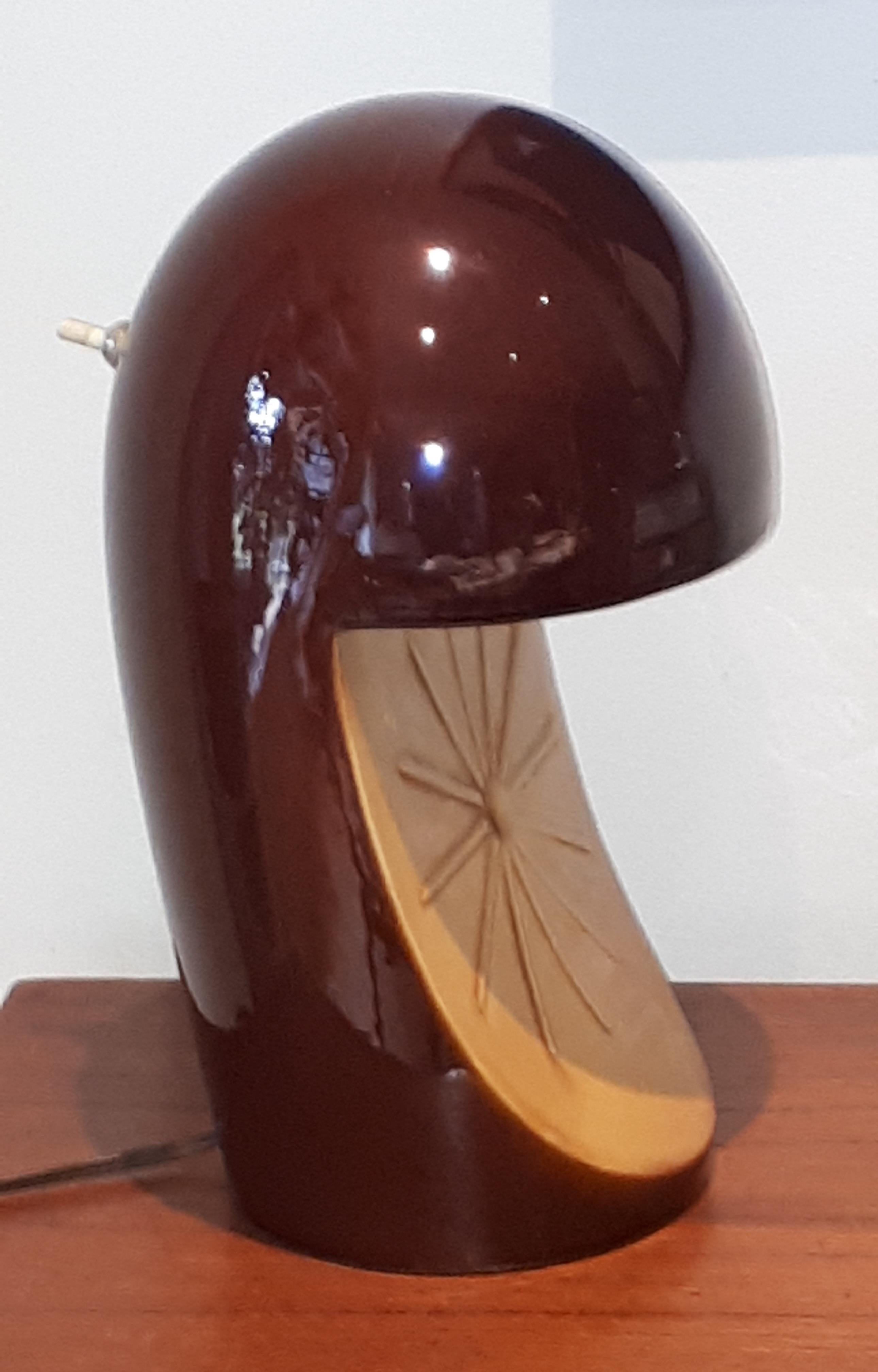 This Mid-Century Modern table lamp is unsigned, but presumed to have been designed by Marcello Caneo of Italy. The lamp is done in a single sculptural ceramic form with a dark brown or coffee colored glaze with a mustard yellow panel in the front