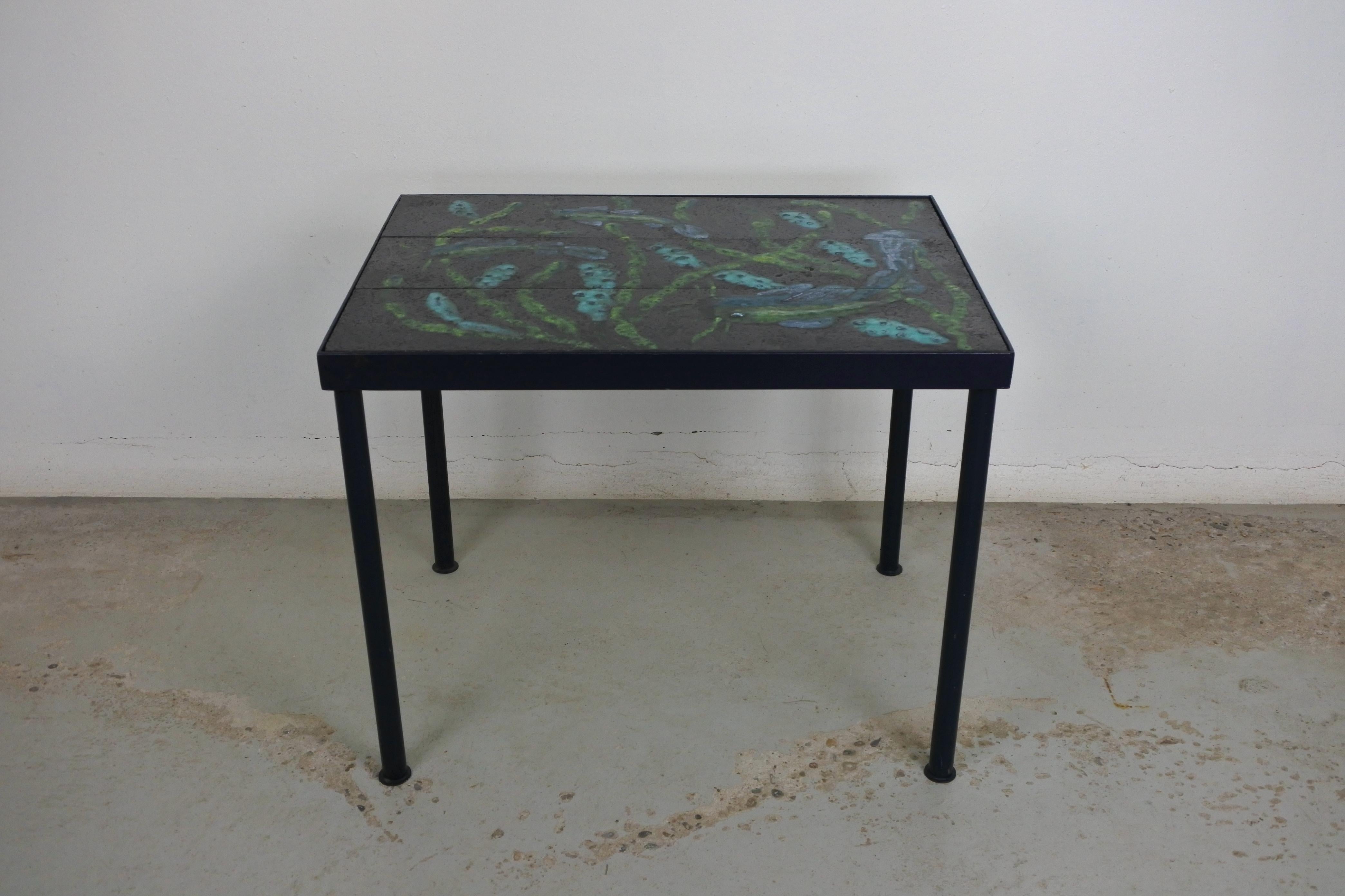 Mid-Century Modern side table.
Blue lacquered metal and enamelled ceramic tiles.
Made in France in the 1950s.

Japan inspired decor of Koï fish. Very decorative

Tables often attributed to Jacques Adnet and La Compagnie des Arts Francais, they