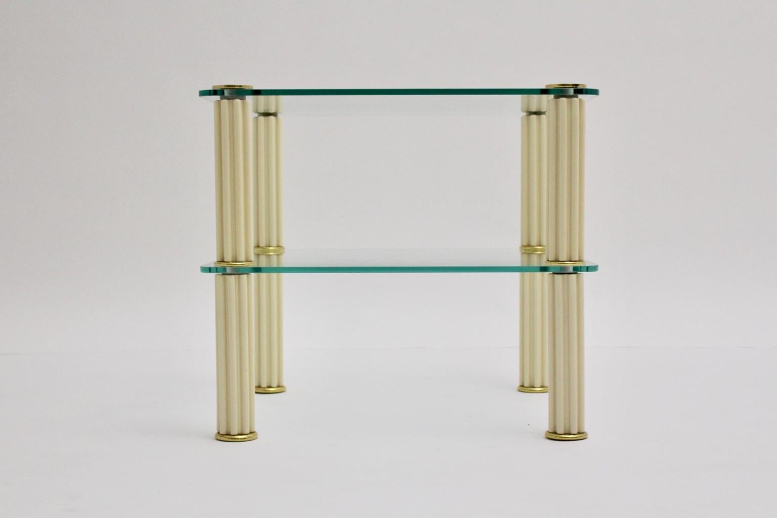Mid Century Modern vintage side table from ceramic and glass in butter cream color tone by Paf Italy.
Consists of four ceramic ivory colored ribbed columns, two colorless glass plates and brass details.
Labeled underneath the column.

approx.