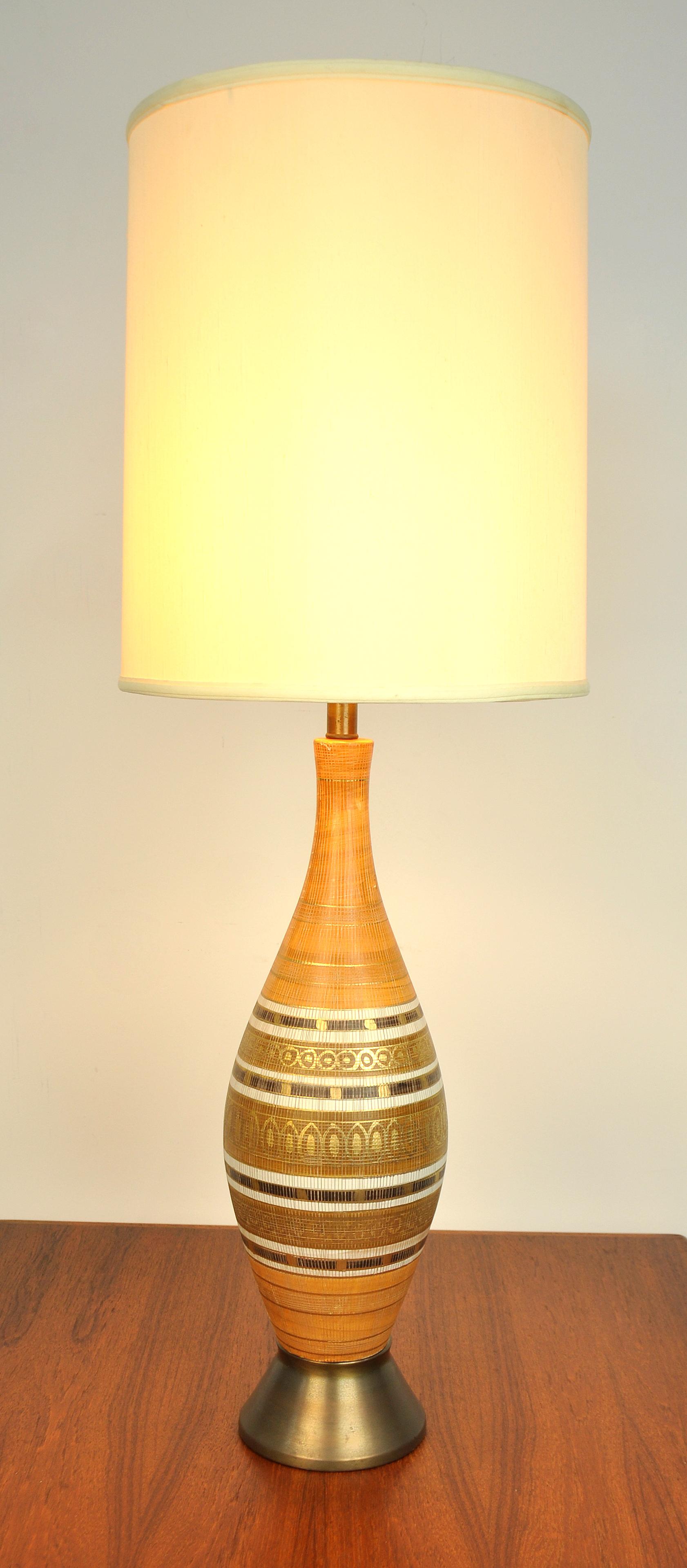 A vintage Mid-Century Modern large and very decorative art pottery lamp, dating from the 1950s. The ceramic lamp features hand gilt decoration on a striped orangey peach, cream or off-white and chocolate brown body, and a patinated brass