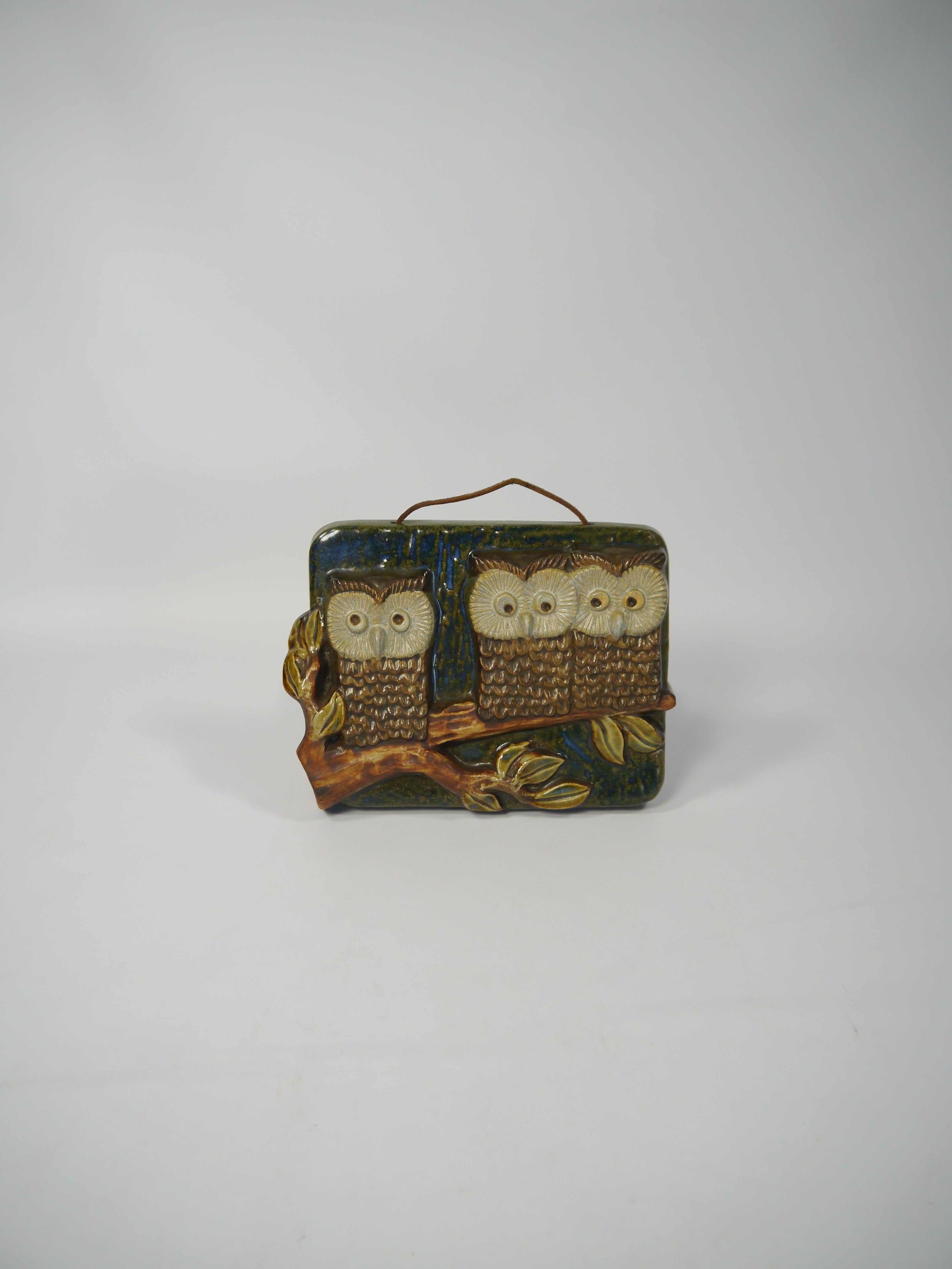 Charming glazed ceramic wall plaque depicting three owls sitting on a branch. Fabricated by EGO Stengods, Sweden, 1960s.