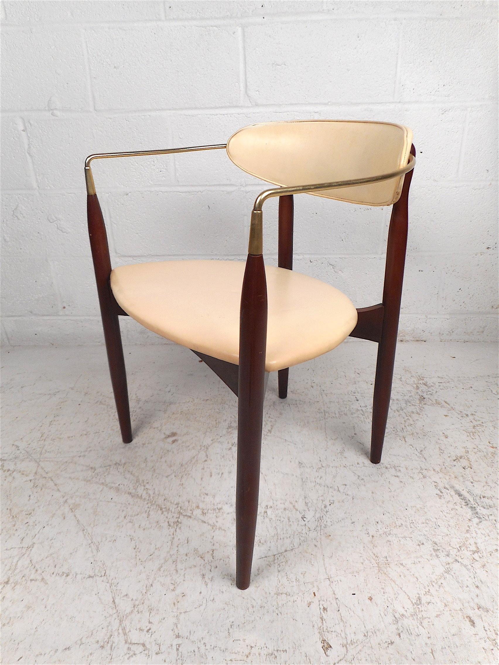 Stylish Mid-Century Modern chair manufactured by Kedawood Furniture. Unusual design with tapered legs, contoured brass armrests, seat and backrest covered in a vintage white vinyl. This chair is sure to make a great addition to any modern interior.