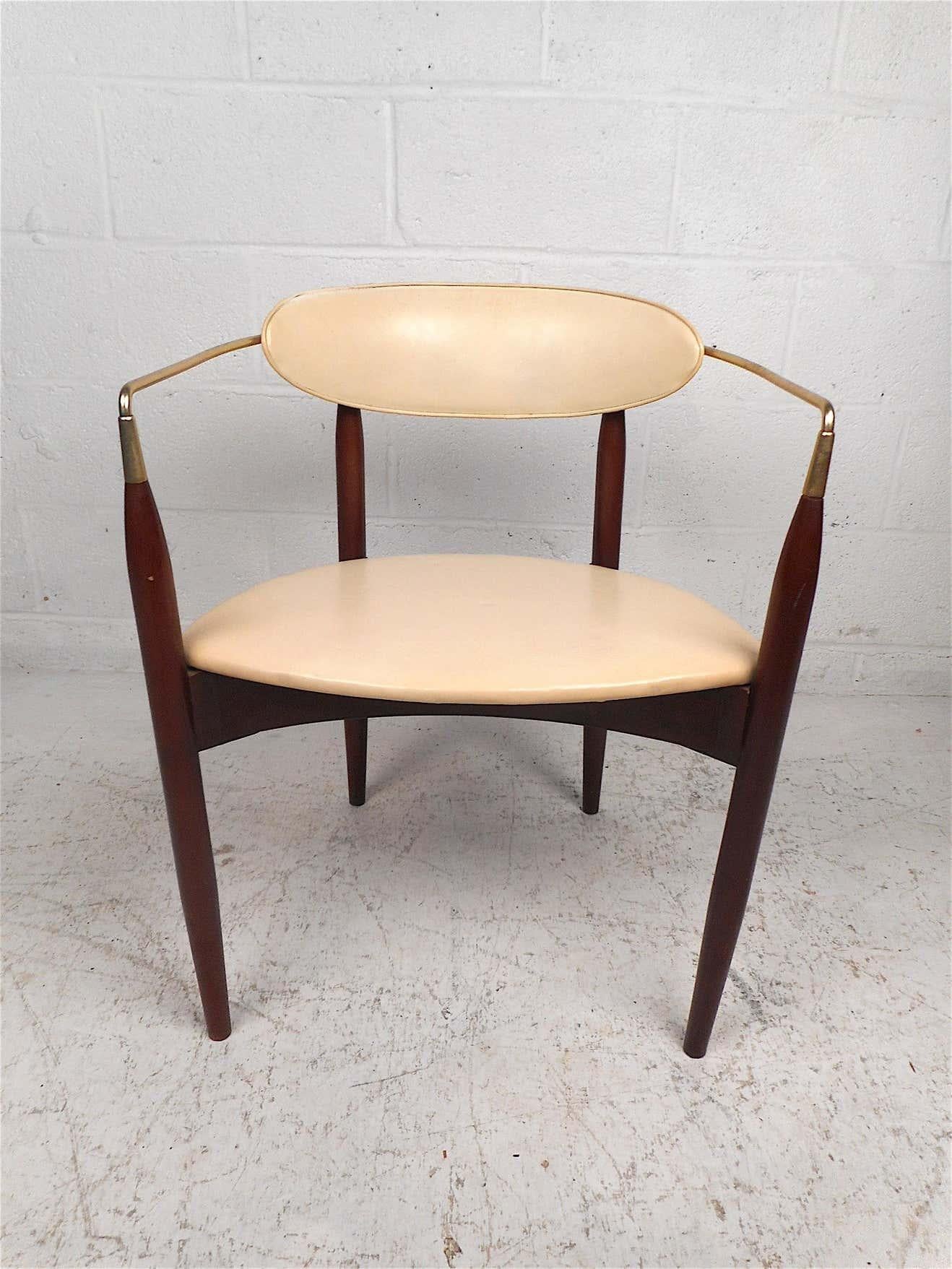 Stylish Mid-Century Modern chair manufactured by Kedawood Furniture. Unusual design with tapered legs, contoured brass armrests, seat and backrest covered in a vintage white vinyl. This chair is sure to make a great addition to any modern interior.