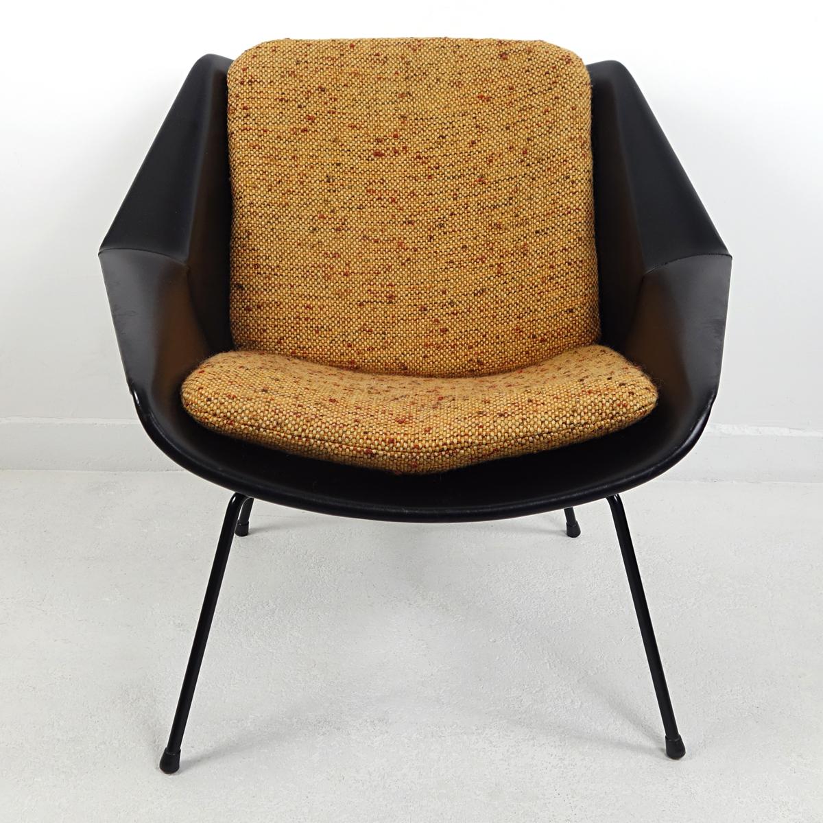 This easy chair was designed by Cees Braakman in the 1950s for famous Dutch furniture manufacturer Pastoe. Its shell is covered in black vinyl, standing on four elegantly shaped black steel legs. The shell holds two loose cushions upholstered with a