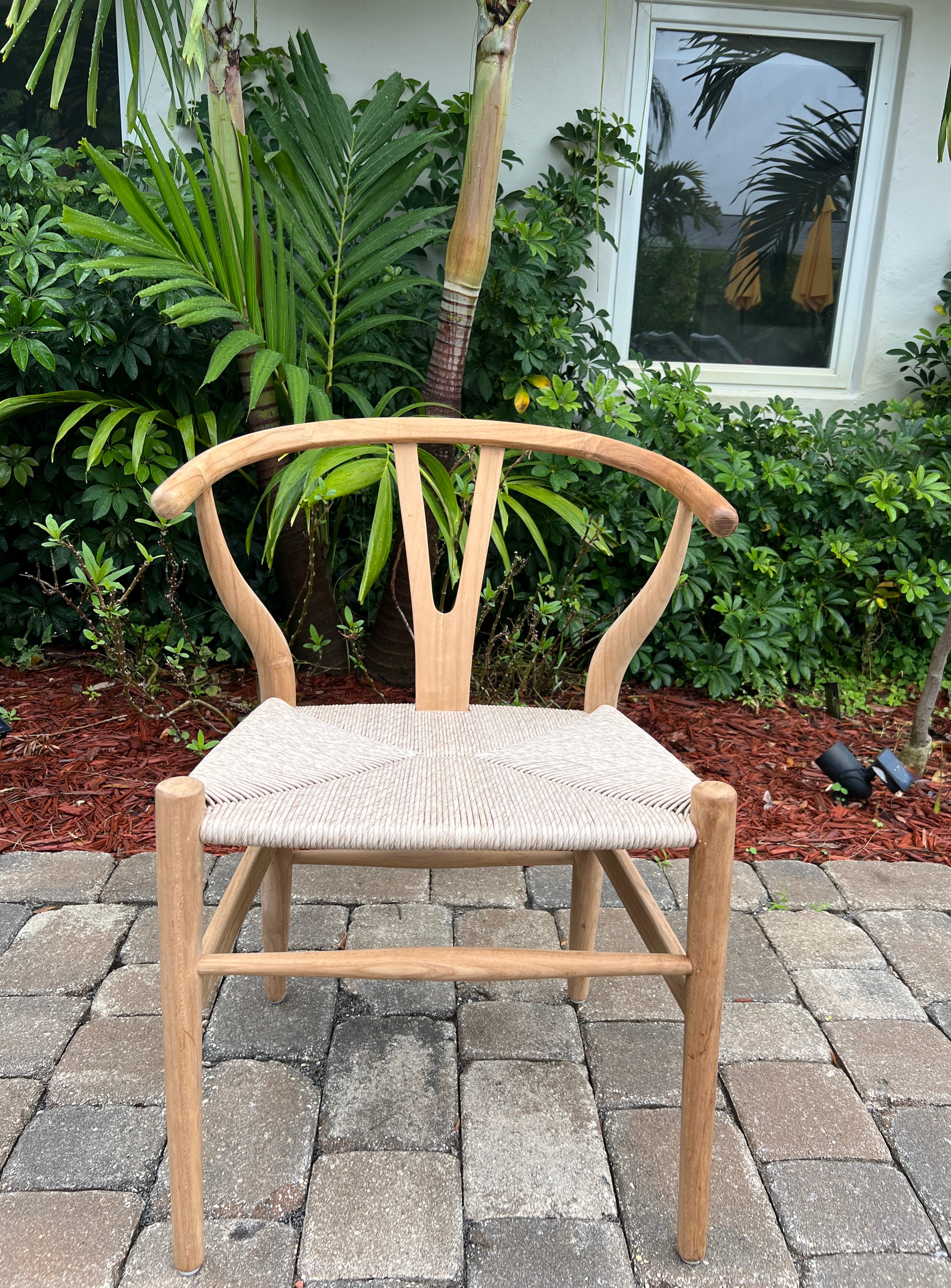 Mid-Century Modern chair in solid teak wood with a natural finish. Handcrafted curved frame features a rounded top with Y-back design. The handwoven cord seat adds to its organic beauty. Classic and timeless design makes this a great accent chair or