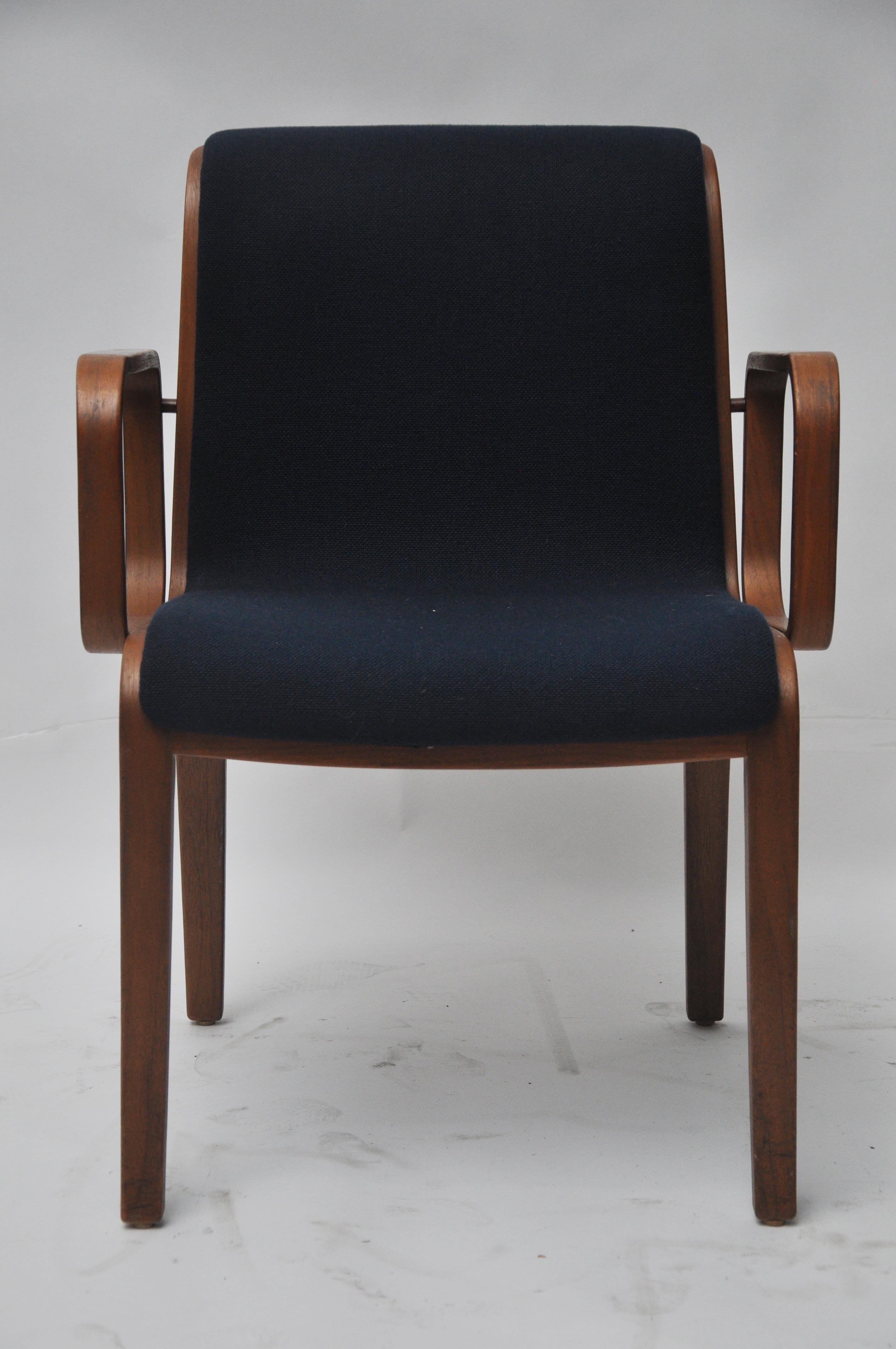 These chairs have a wooden frame and have original navy blue upholstery with no rips or tears. Very comfortable. They would benefit from being cleaned or reupholstered. Measures: Arm height is 26