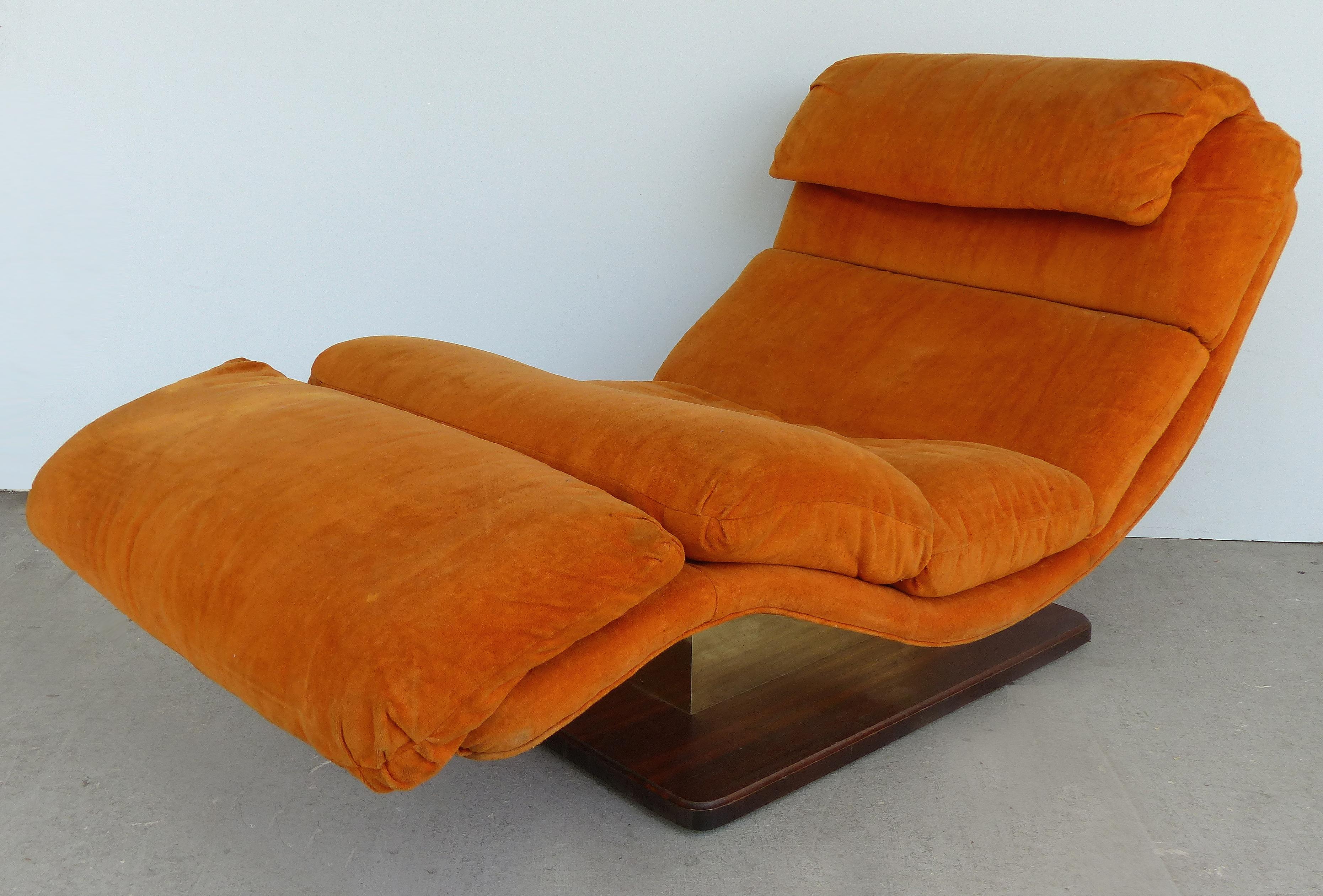 Offered for sale is a stylish Mid-Century Modern chaise longue by Carson's of High Point., N.C. An ultra-comfortable wave chaise longue after Milo Baughman with an S-shaped, generously wide design with a brass and walnut floating base. Upholstery