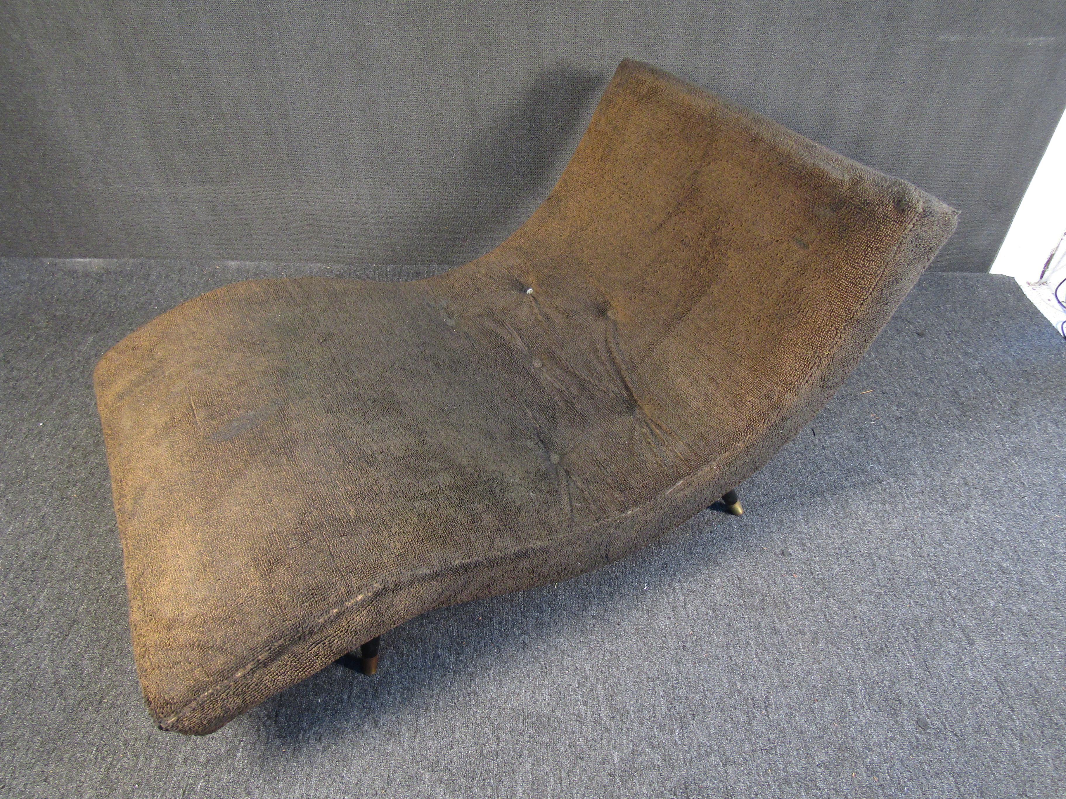 A Mid-Century Modern chaise lounge that combines an interesting form with rich brown upholstery. With a comfortable curving back, this chaise is perfect for reclining after a long day. Please confirm item location with seller (NY/NJ).