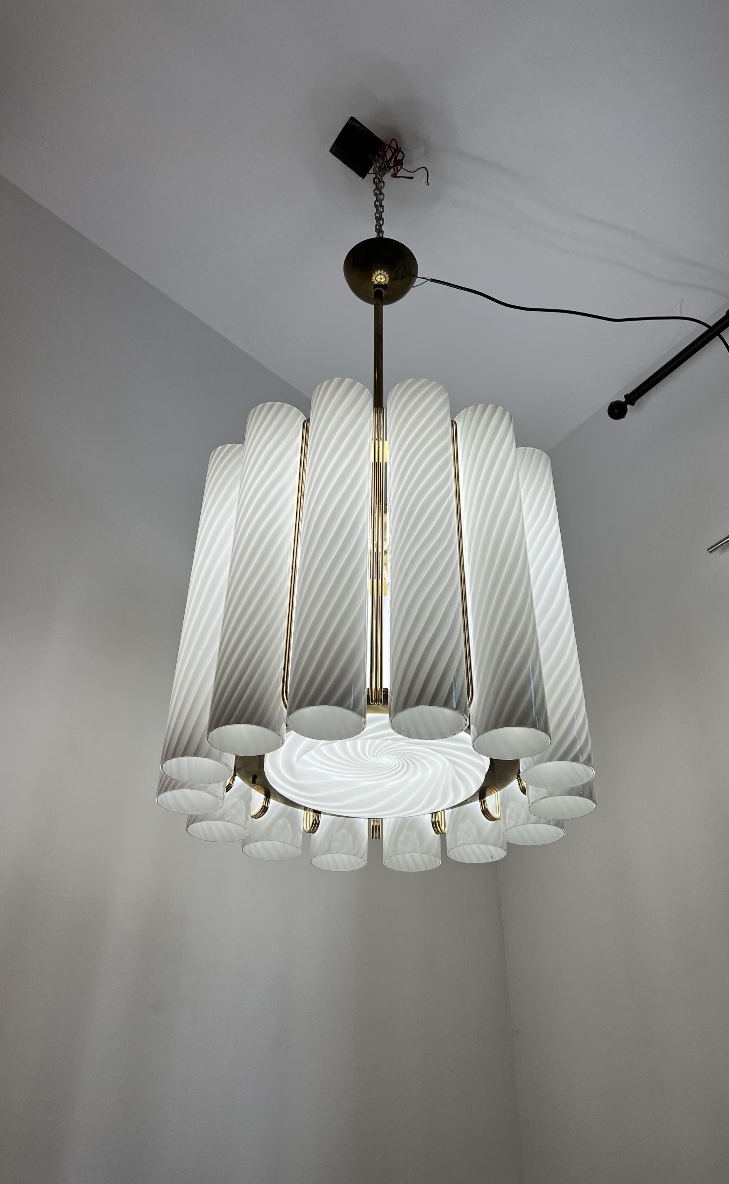 Beautiful and large Mid Century Modern, drum shaped chandelier.
Manufactured in lacquered metal, brass and hand-blown Murano glass.
Composed of fourteen large murano glass tubes (20 inches long)  and one central disk, all executed in a translucent