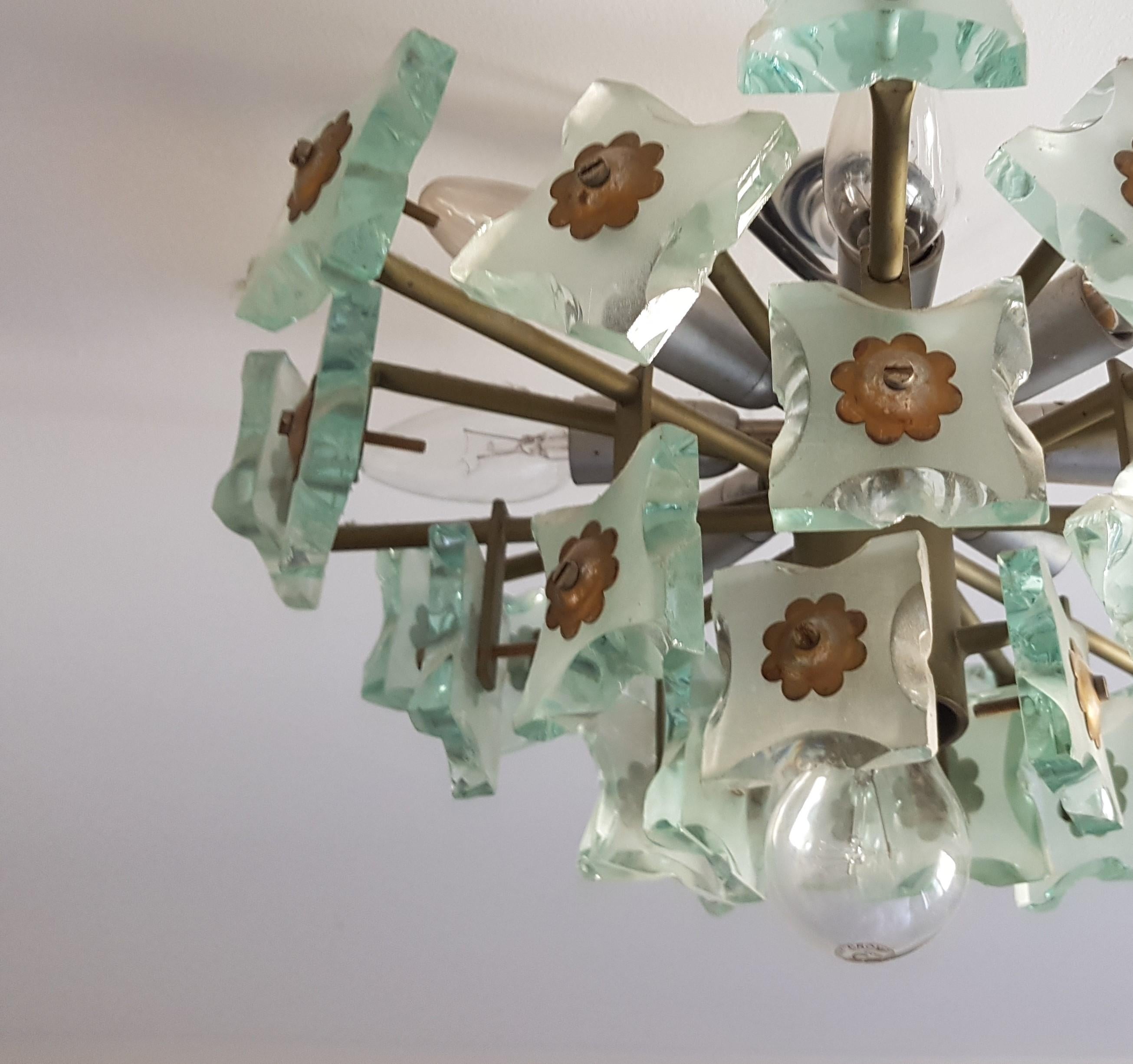Unusual glass, brass and metal chandelier attributed to Fontana Arte. This is a useful piece as it has a low drop so is suitable for installation in rooms with lower ceilings. The shaped, thick, heavy glass shades are beautifully shaped and the pale