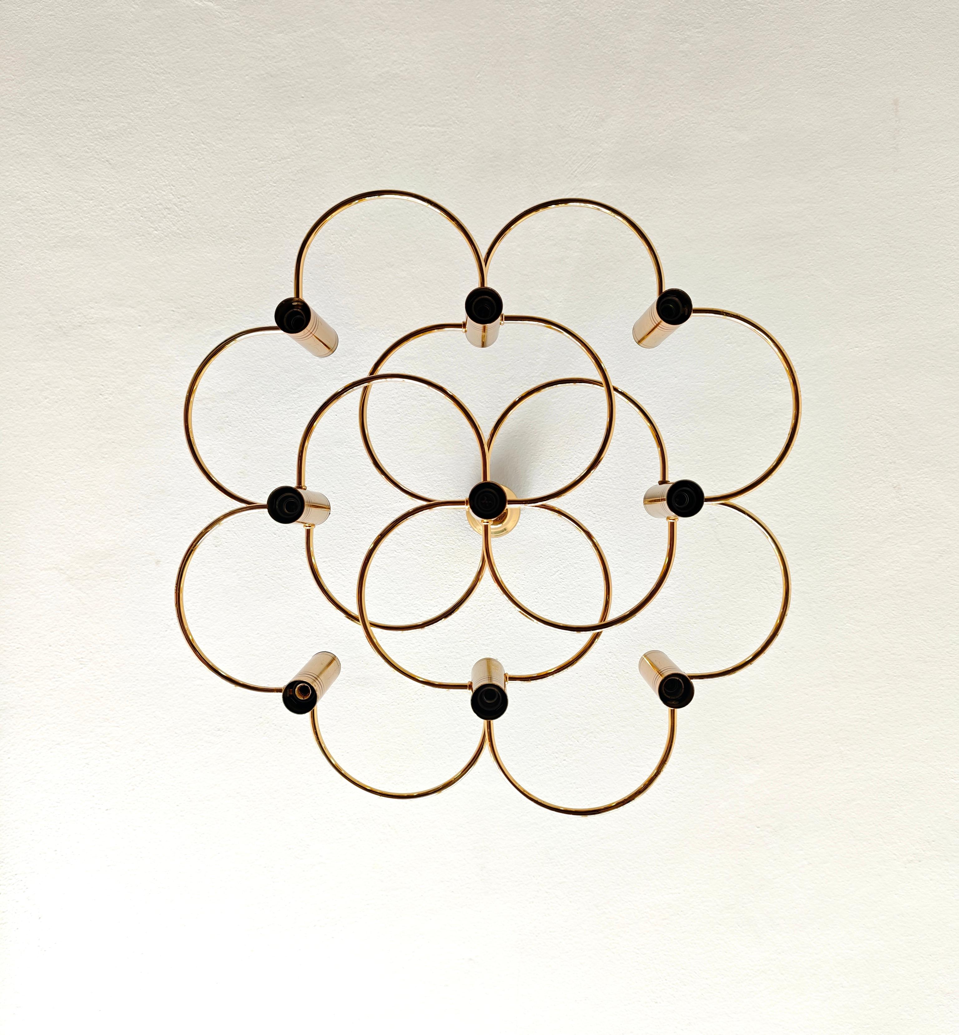 Una icónica lámpara de araña diseñada por Gaetano Sciolari en la década de 1970. Sciolari, diseñador de iluminación italiano, era conocido por crear aparatos de iluminación elegantes y modernos a mediados del siglo XX. Una lámpara de araña de nueve