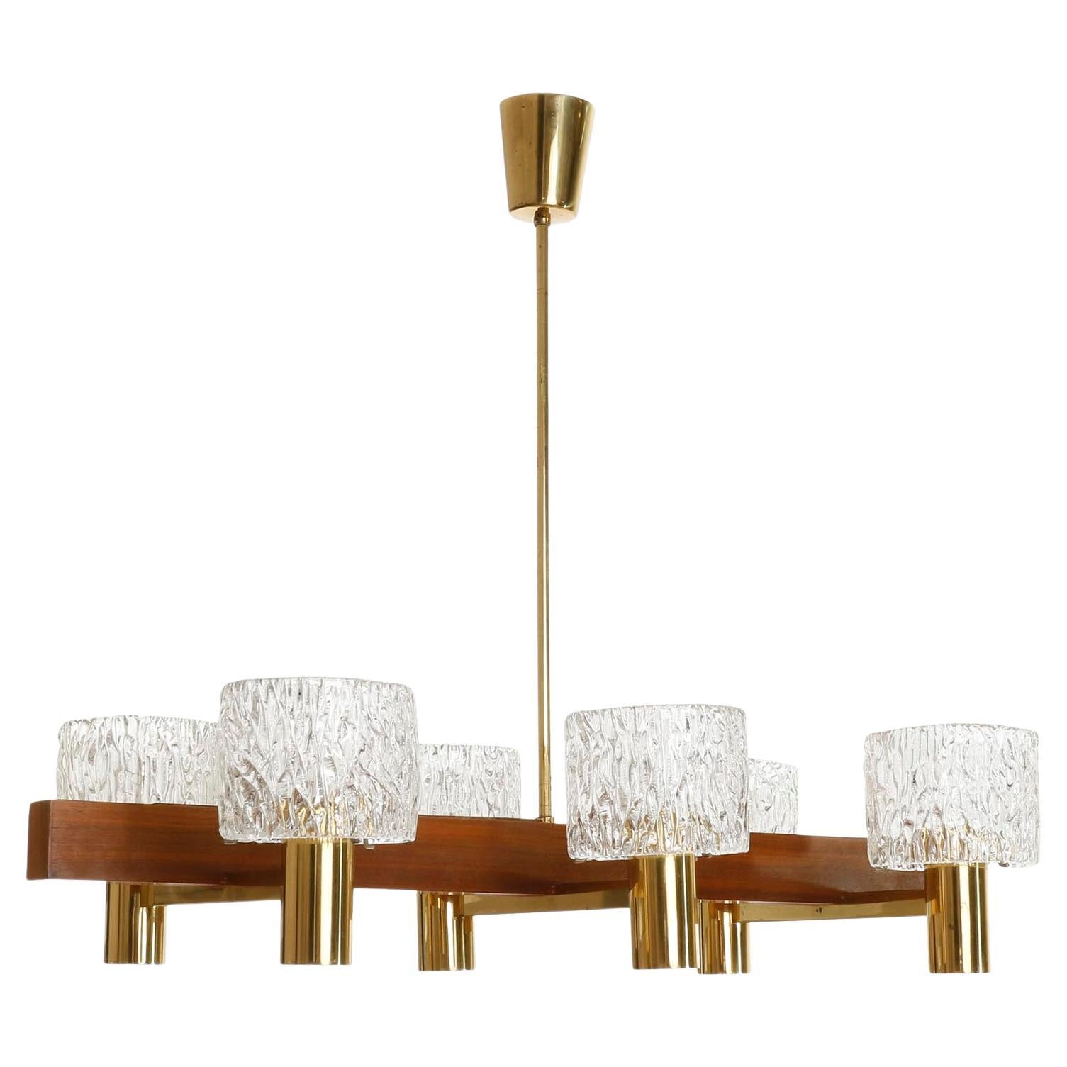 A six-arm chandelier by J.T. Kalmar, Vienna, manufacured in Mid-Century in 1950s or early 1960s. 
The fixture is made of a nice mixture of materials: textured clear glass lamp shades, brass and warm walnut wood.
The length of the rod can be altered