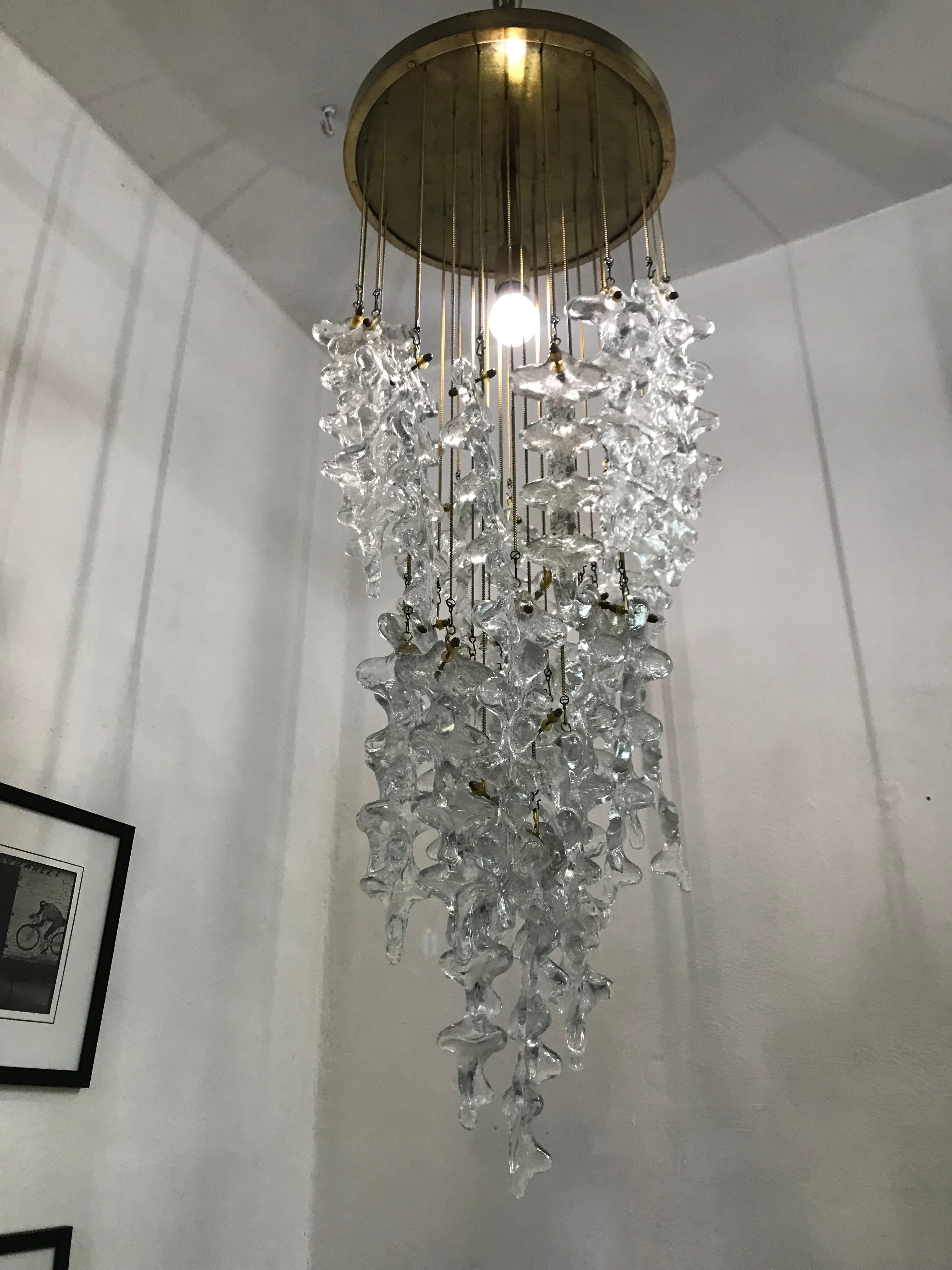 Large multi-tiered chandelier in hand blown Murano glass by Venini , Italy, circa 1970.
Comprised of several pieces of glass resembling icicles, hanging from brass chains in 3 concentric circles.
The length of the chains can be adjusted as wished