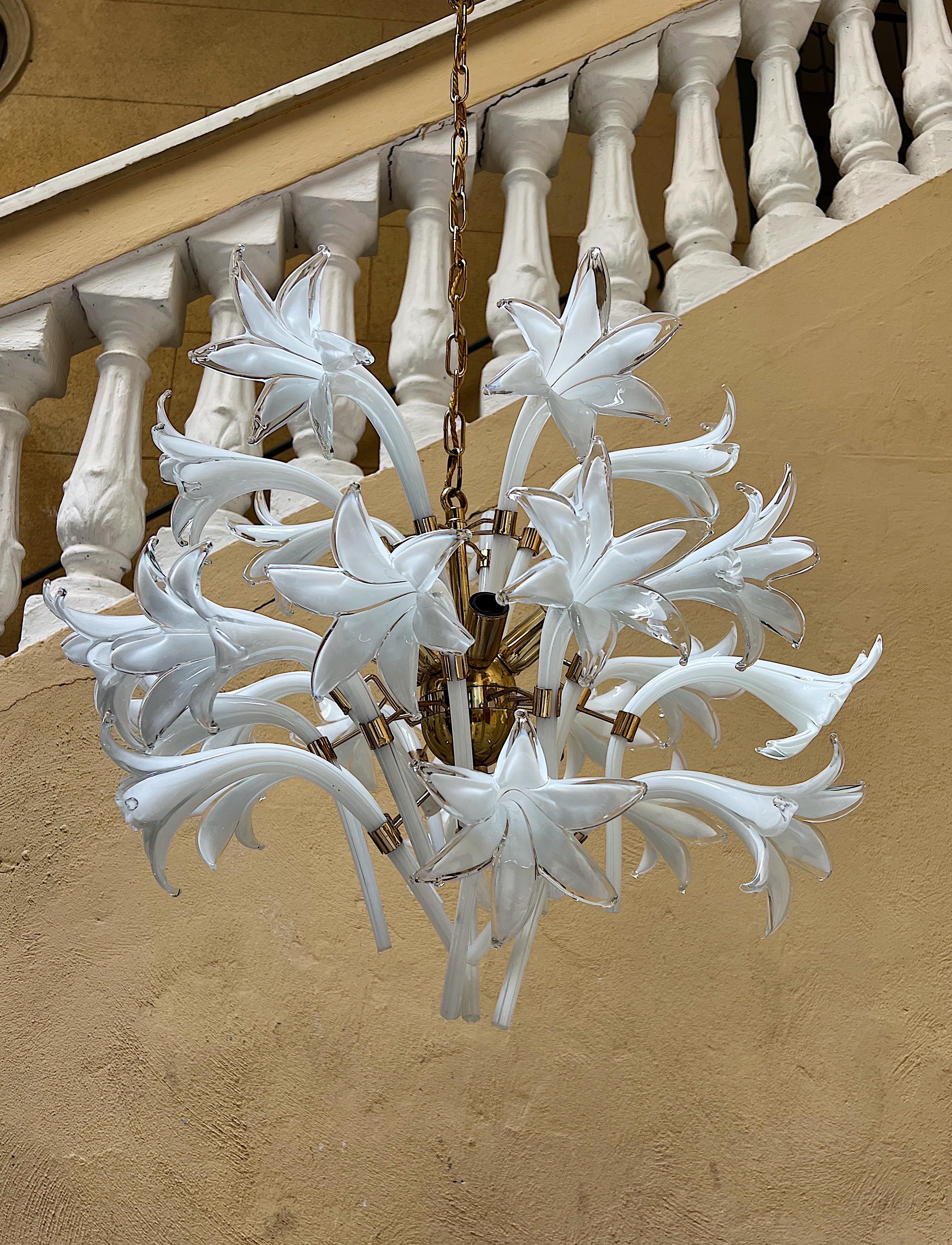 Seltener Kronleuchter aus Murano-Glas, entworfen von Franco Luce in den 1970er Jahren.
Die Leuchte besteht aus einem goldenen Metallsockel mit weißen Blumen.

Die hohe handwerkliche Qualität macht dieses Stück zu einem wertvollen