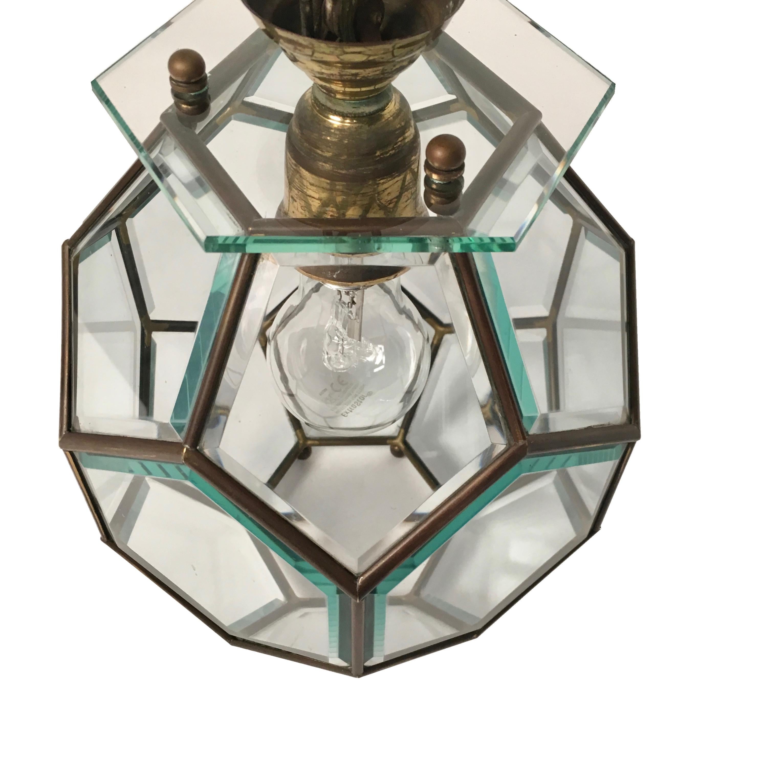 This beautiful shiny lantern has a hexagonal shape and presents a brass frame and many fragments made of cut shiny crystal glass.
In the middle of the lantern is the bulb holder for one big Edison bulb. All details as well as chain and canopy are