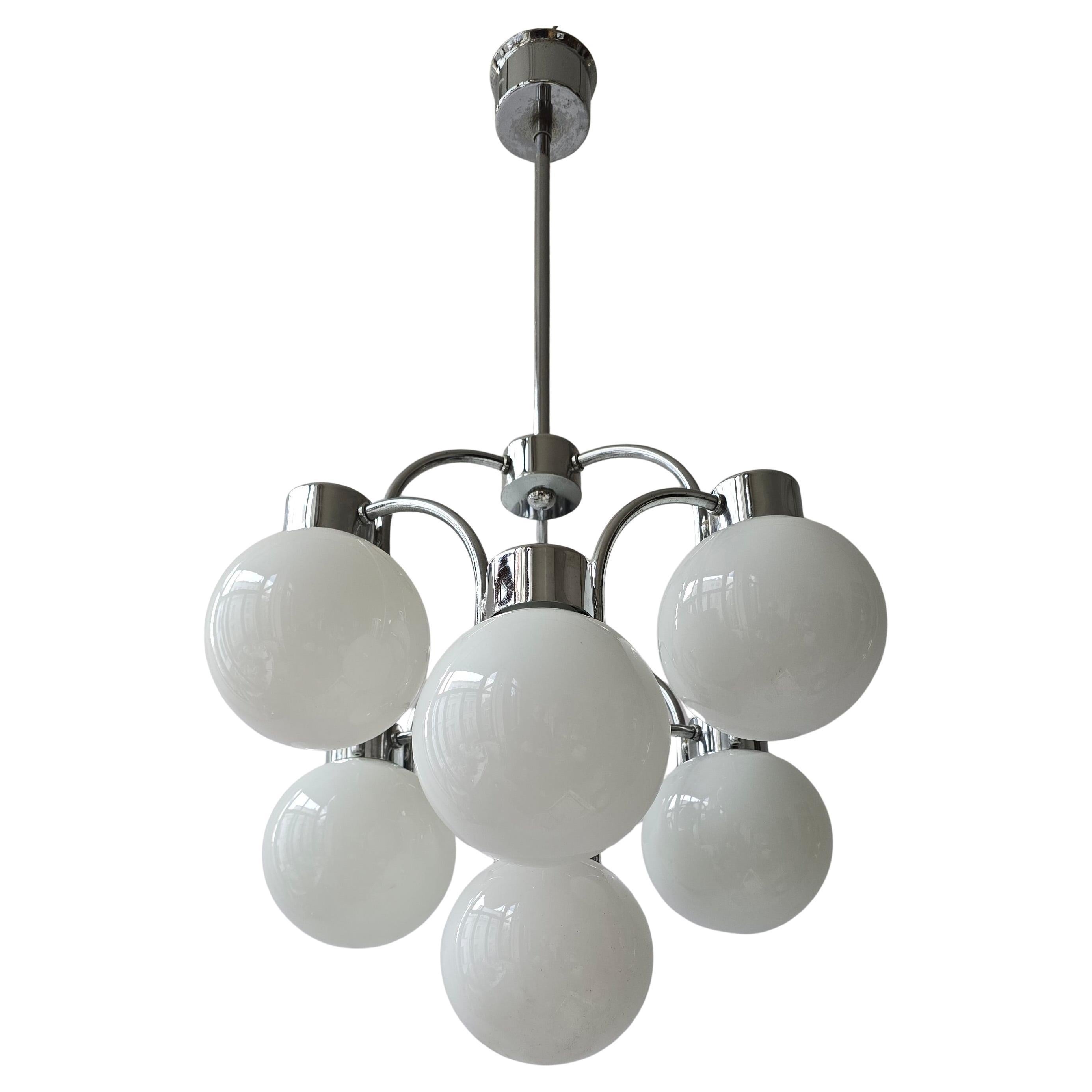 Lampadario moderno di metà secolo in cromo e vetro di latte (anni '60/70)

La lampada ha una forma elegante e simmetrica con sei globi di vetro al latte, fissati su un supporto cromato lucido. 
La combinazione tra il cromo lucido e la luce morbida e