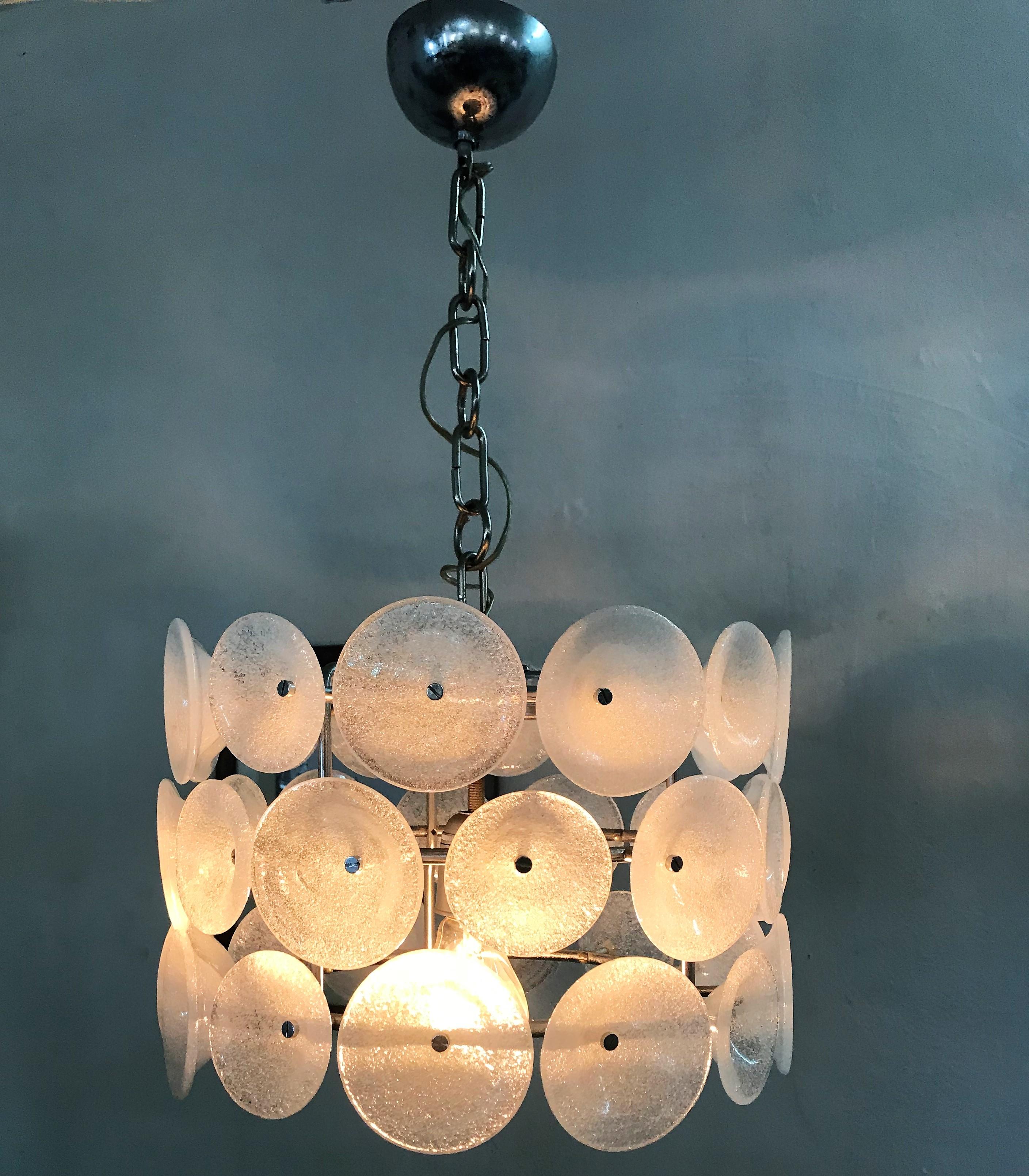 Italian Space Age chandelier or pendant light attributed to Vistosi consisting of 36 Murano glass disks in two different sizes in the Pulegoso glass technique, circa 1960.
 